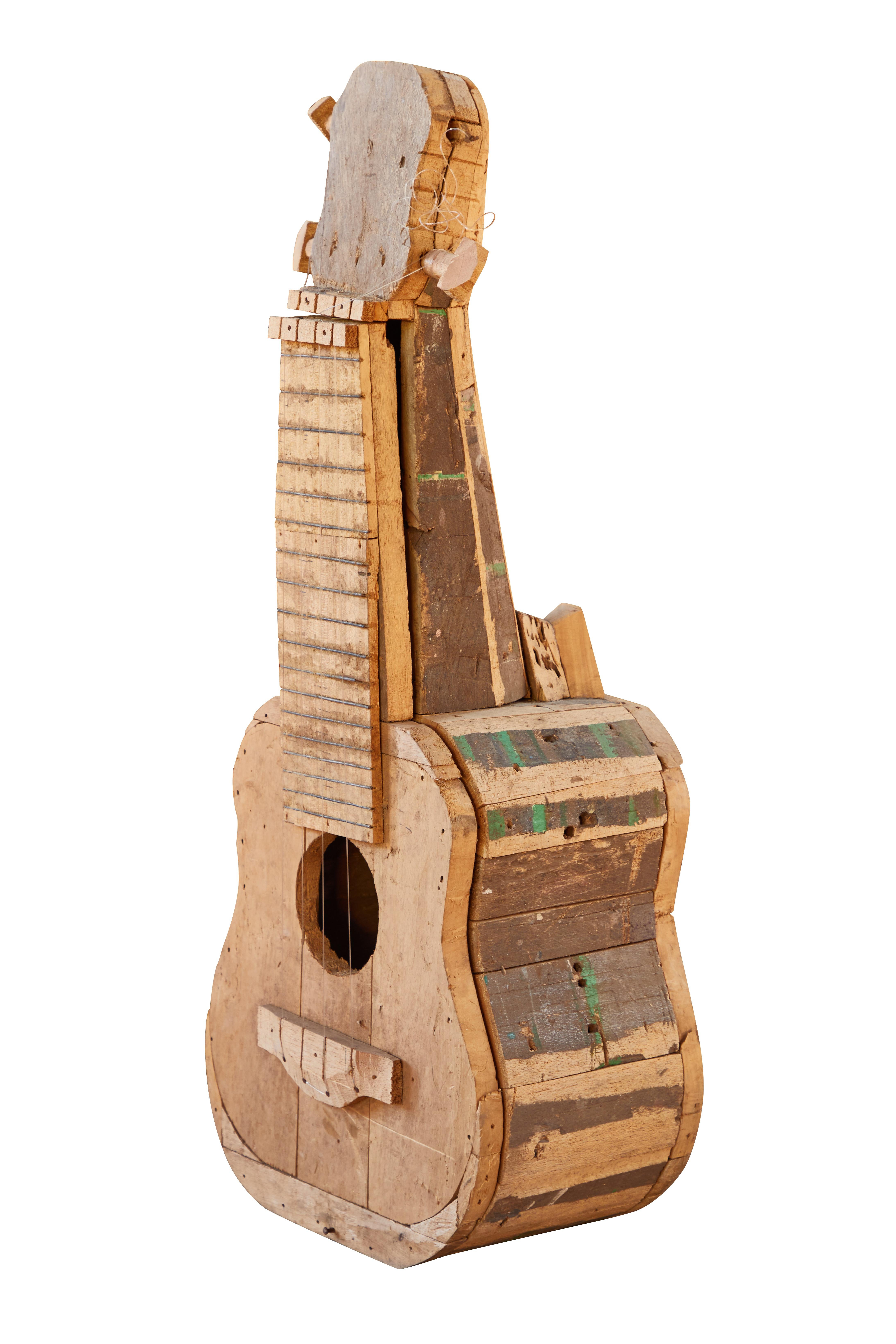 Large reclaimed wood guitar sculpture by African Folk Artist Nii Adum. Handcrafted from recycled woods in Ghana. With the advent of colonization, African carvers began to work European subjects into their repertoires, as well as into their musical