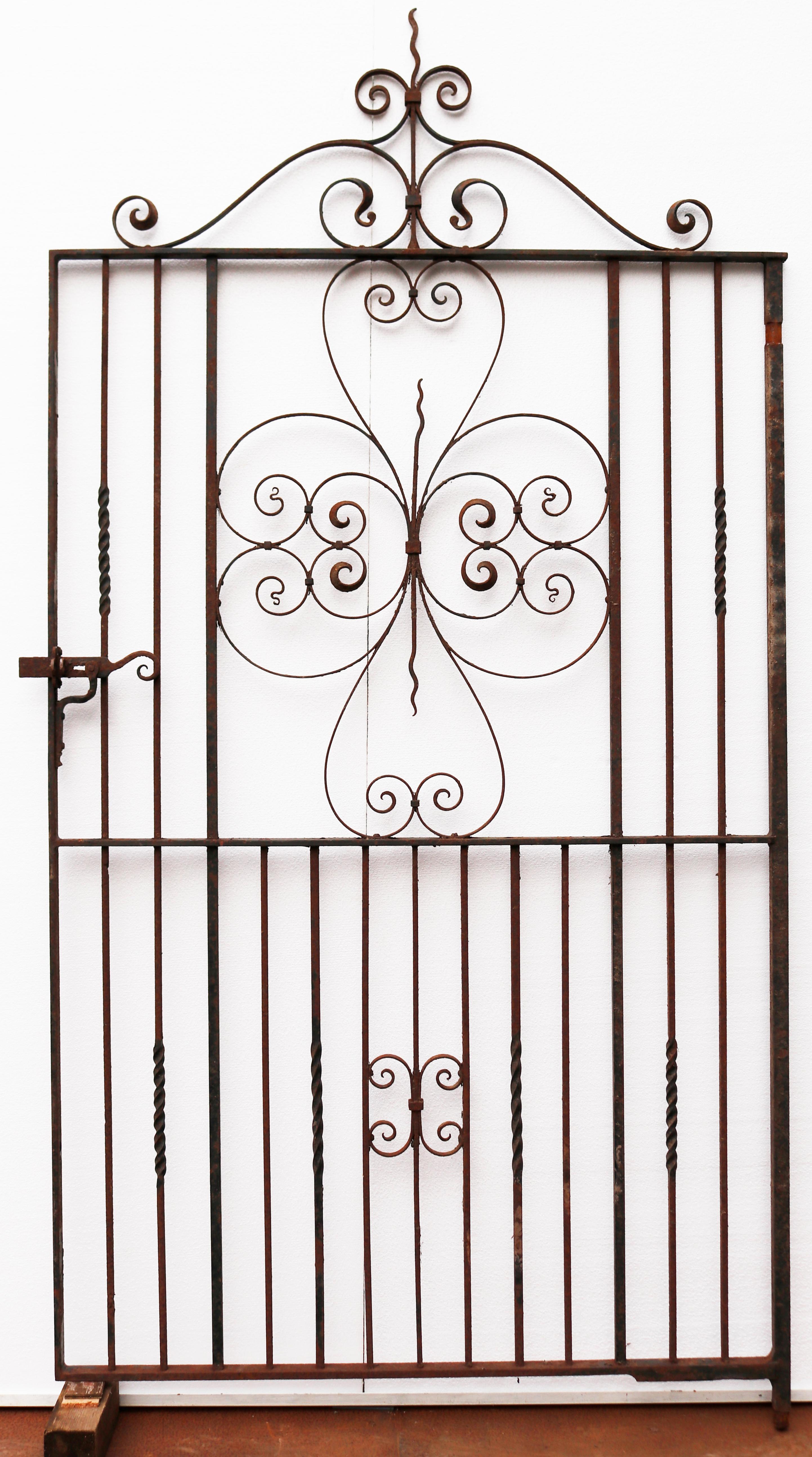 A large reclaimed garden gate made from wrought iron.