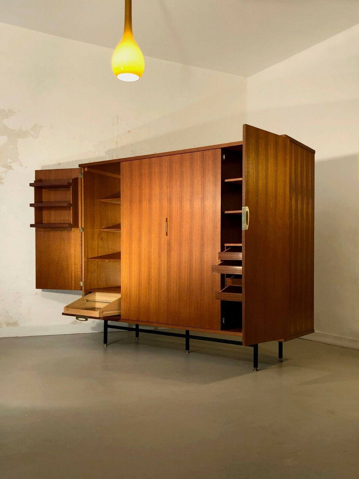 A large wardrobe with a rational storage system, with 4 doors, one of them holding a mirror creating a beautiful asymmetry;  Moderniste, Reconstruction, structure in wood veneer set down on a structure of 5 feet in bronze and black lacquered metal,