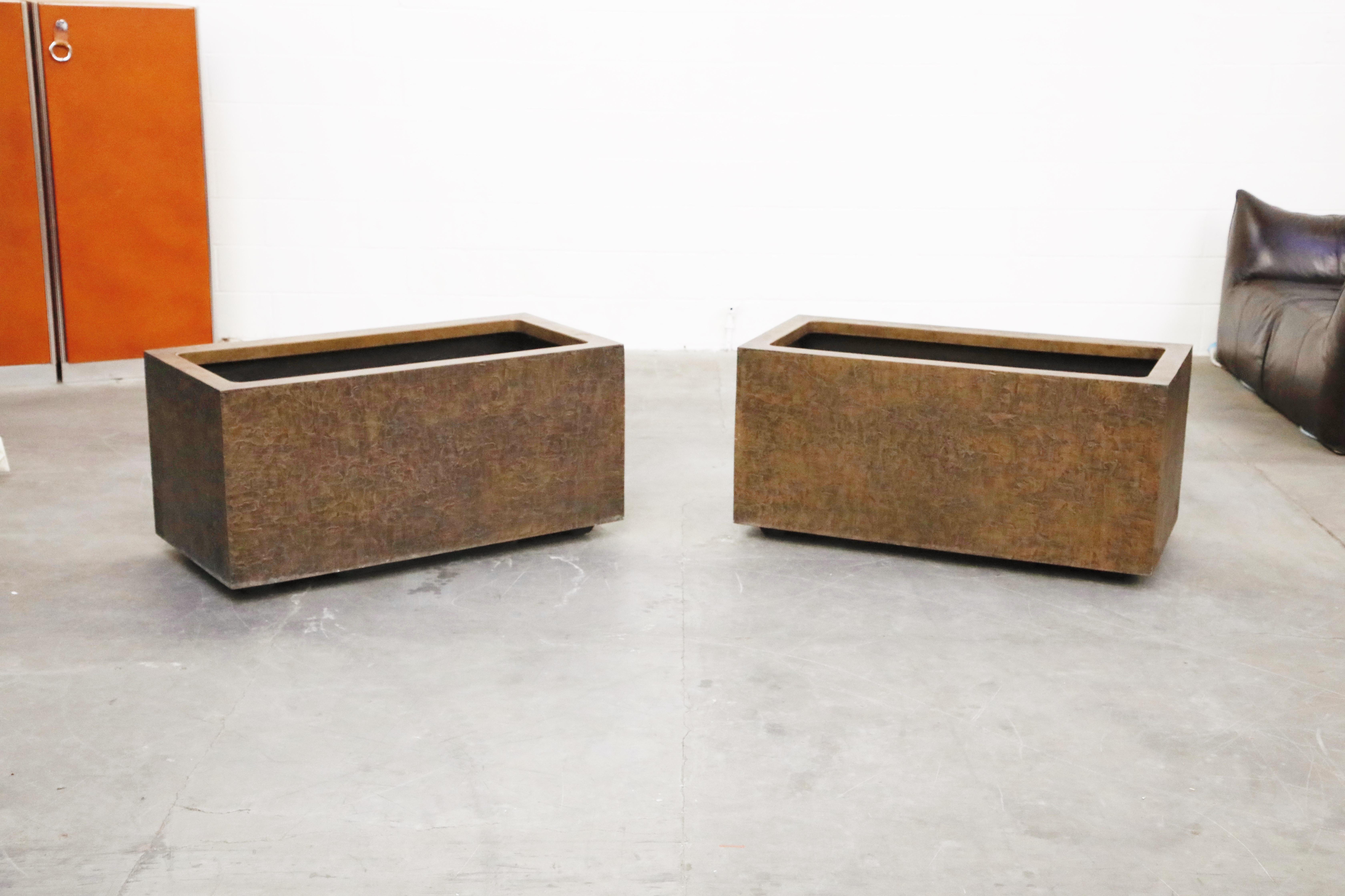 A pair of rare architectural fiberglass planters by Forms and Surfaces designed and produced in the 1970s. These large impressive rectangular pots feature a Brutalist textured bronze colored fiberglass exterior. These large planters are suitable for
