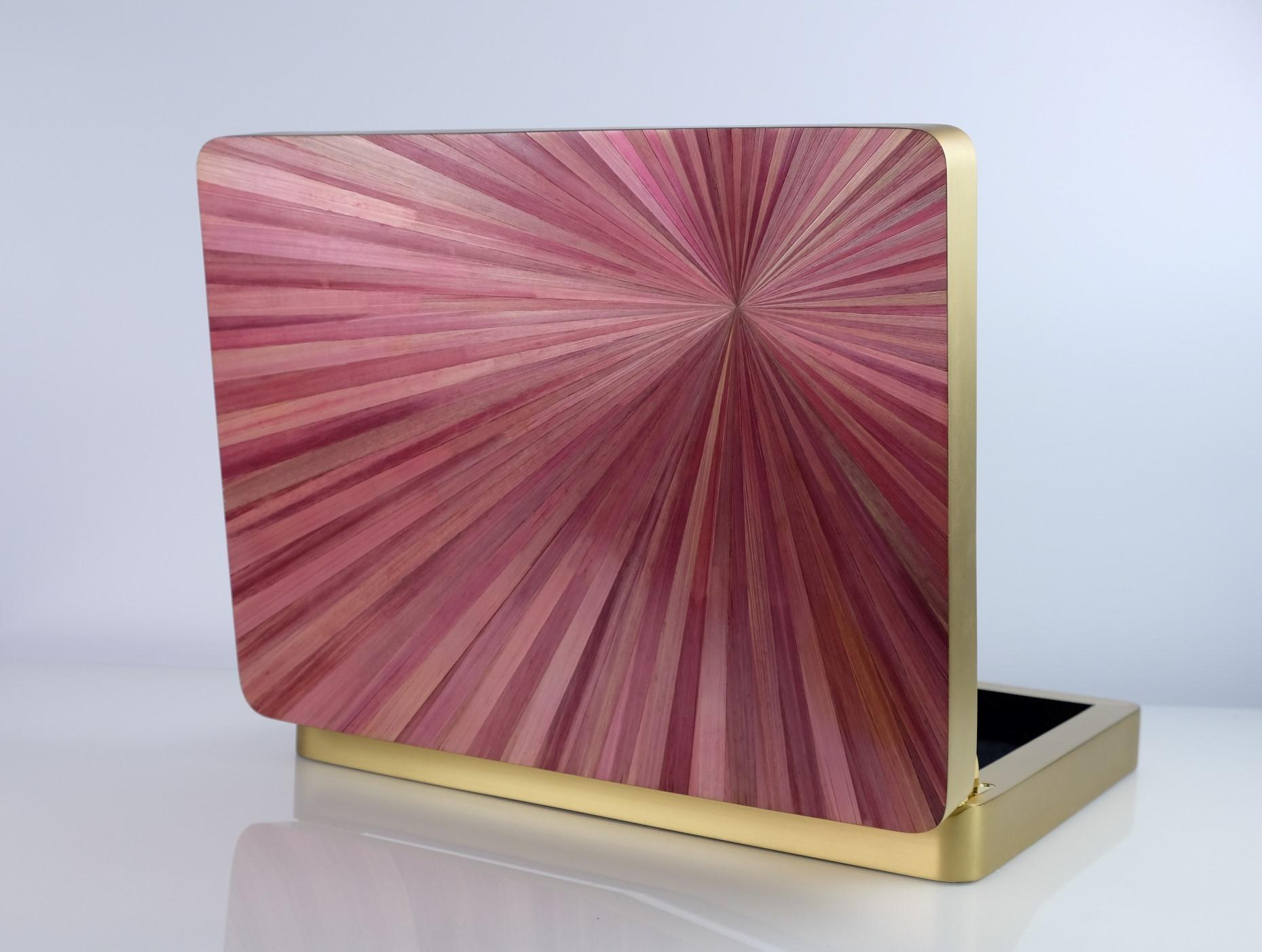 This lovely rectangular brass box with rounded corners, is made of brushed brass with a lid covered of straw marquetry.
The radial design of the straw reminds the great Art deco period while the elegant pink color contrasts perfectly with the gold