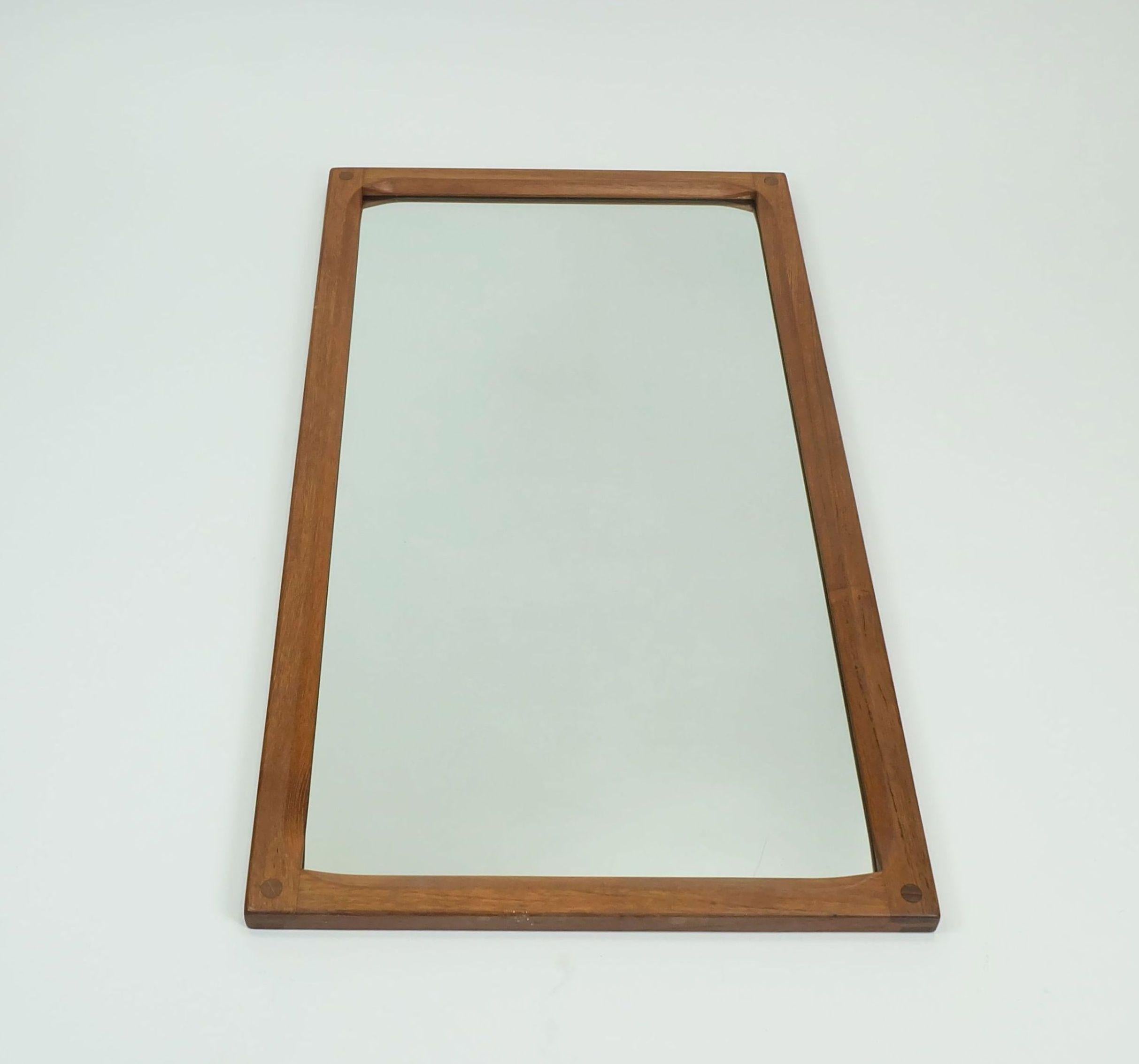 A very beautiful large rectangular 1970s wall mirror manufactured by Aksel Kjersgaard, Odder, Denmark. The frame is made of solid teak wood

Dimensions in cm: 
Length 80 cm, width 44 cm, depth 2 cm.

Dimensions in inches: 
Length 31.49