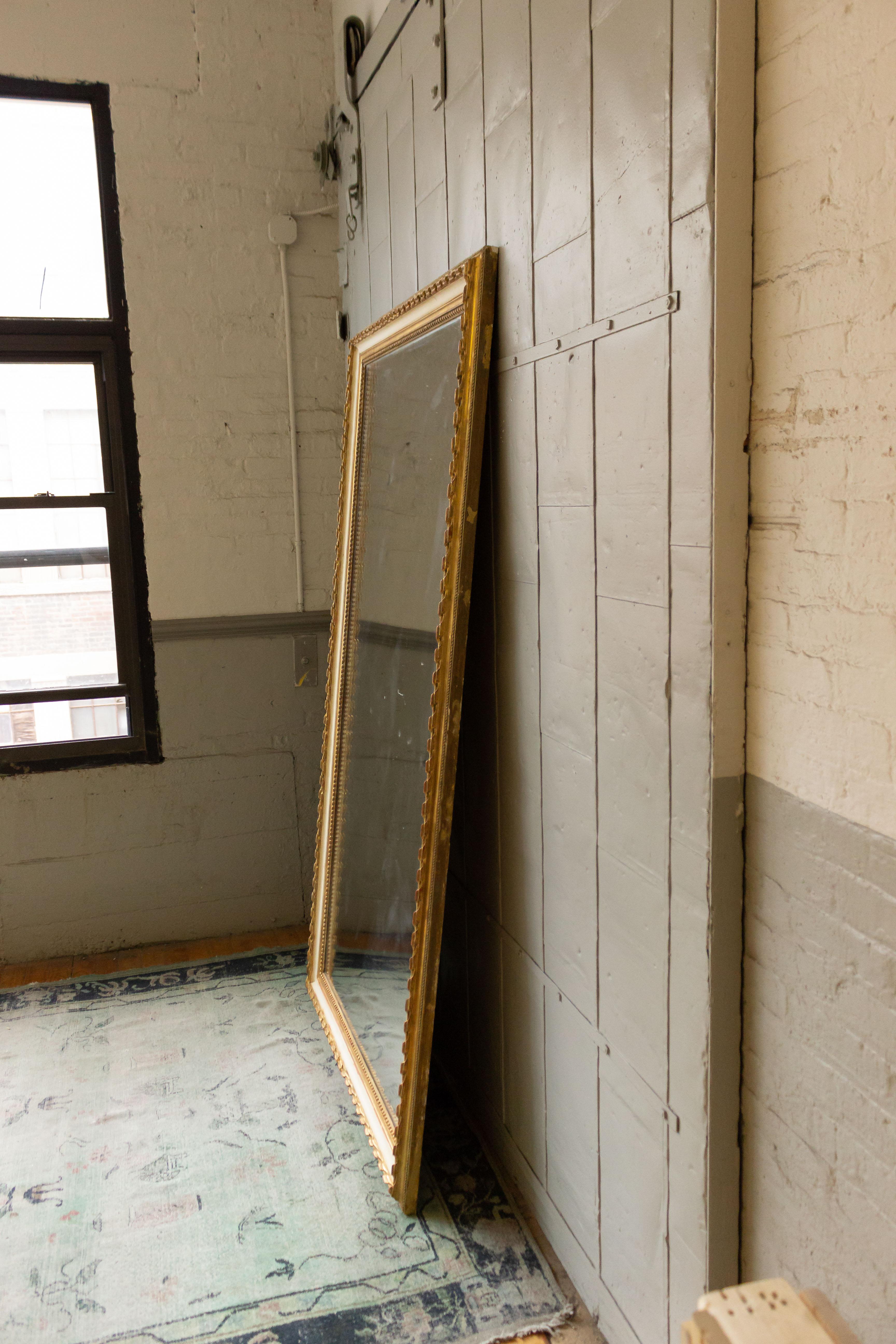 Large scale 19th century French mercury mirror in a carved giltwood frame with off white painted contrast. The mercury glass and wooden backing are original to the mirror. A cleat hanging system has been installed to the back of the mirror. Very