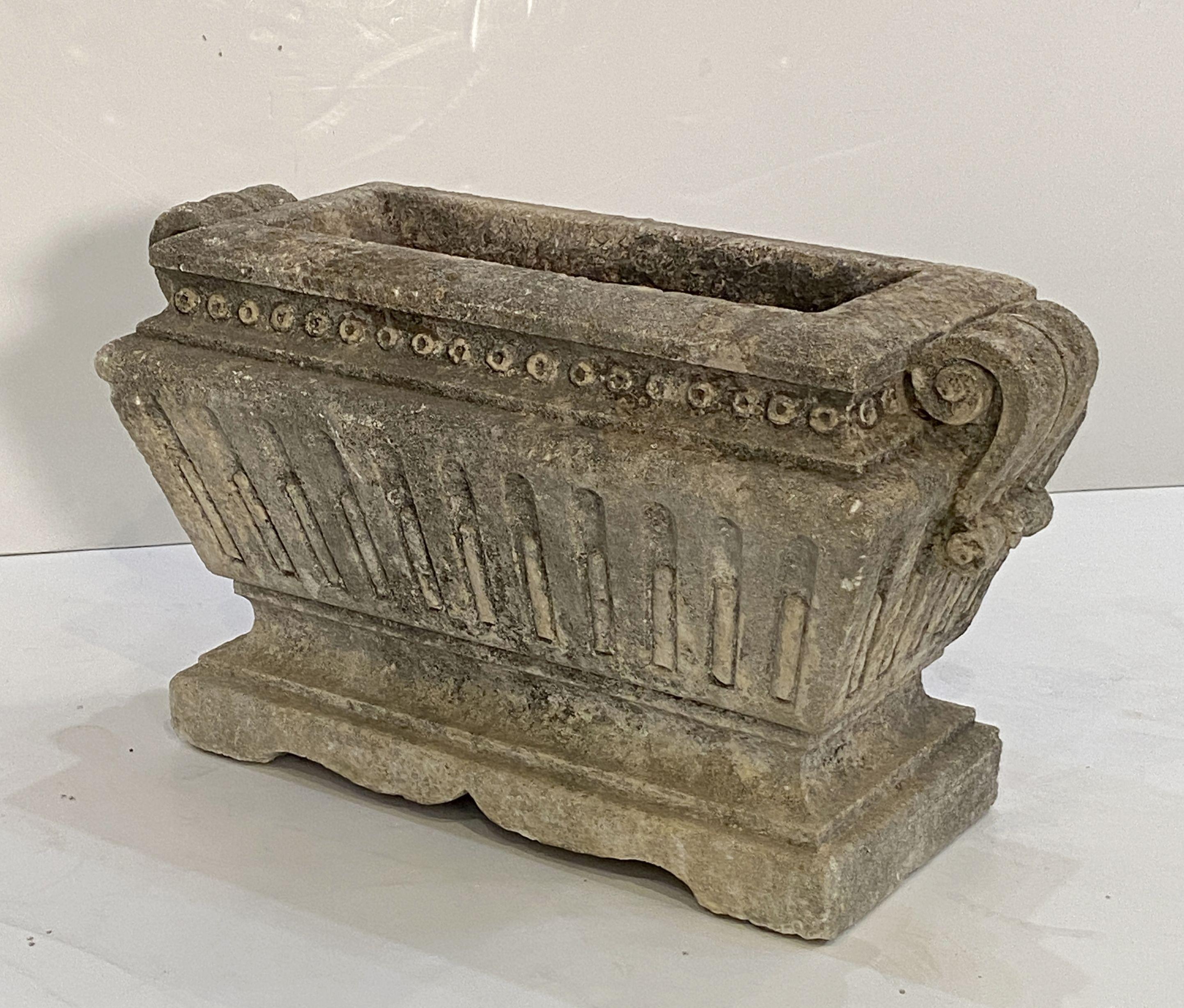 A fine large rectangular English garden trough or planter of composition stone, in the Classical style, featuring a raised top with scroll-work handles on a shaped base.

 