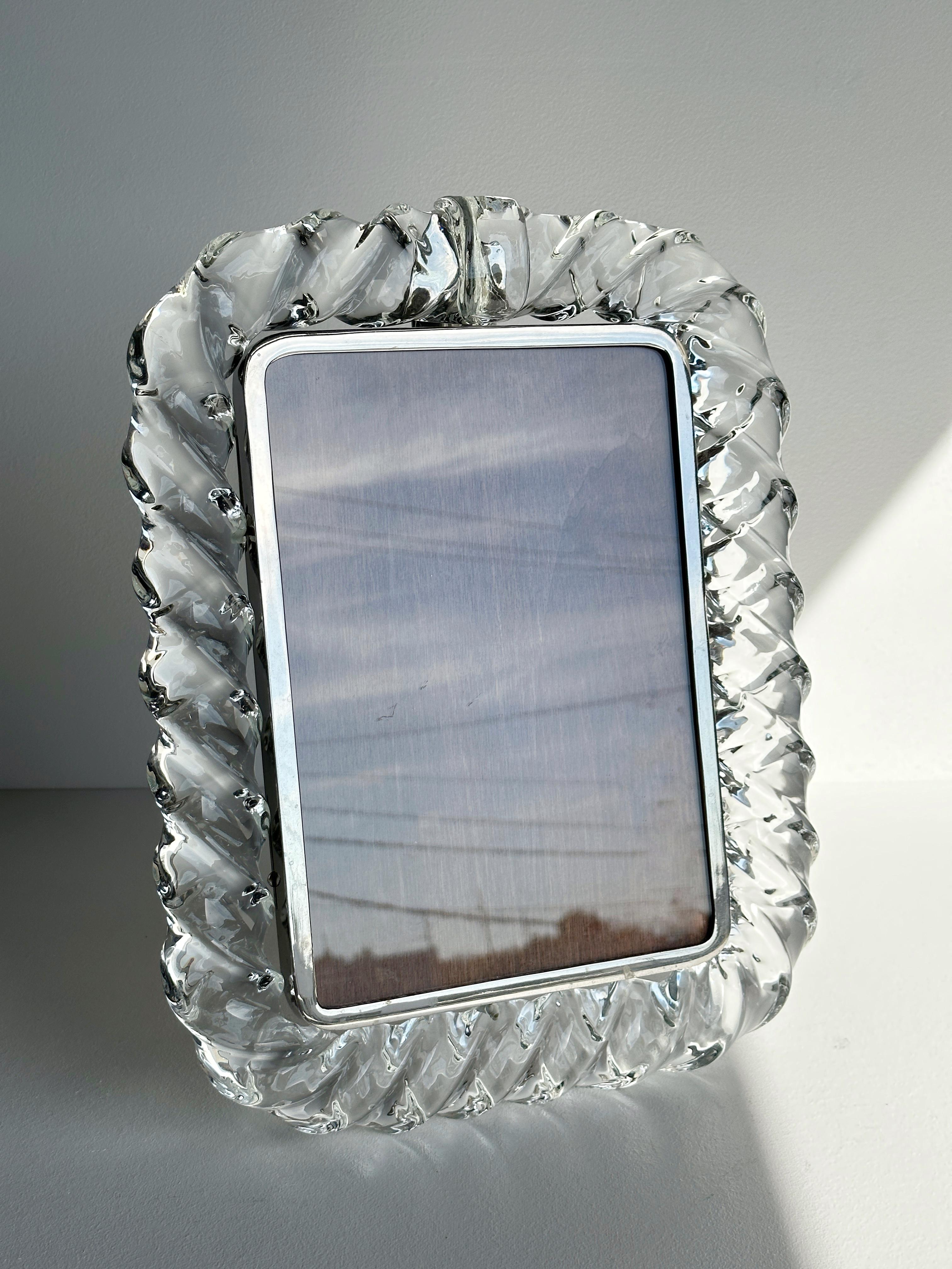 Large and beautiful Murano glass “rope twist” picture frame with metal t-stand. Shows very well with minimal wear, one area chipped in the interior where the post connects metal frame to glass, not visible to the eye from the front and only visible