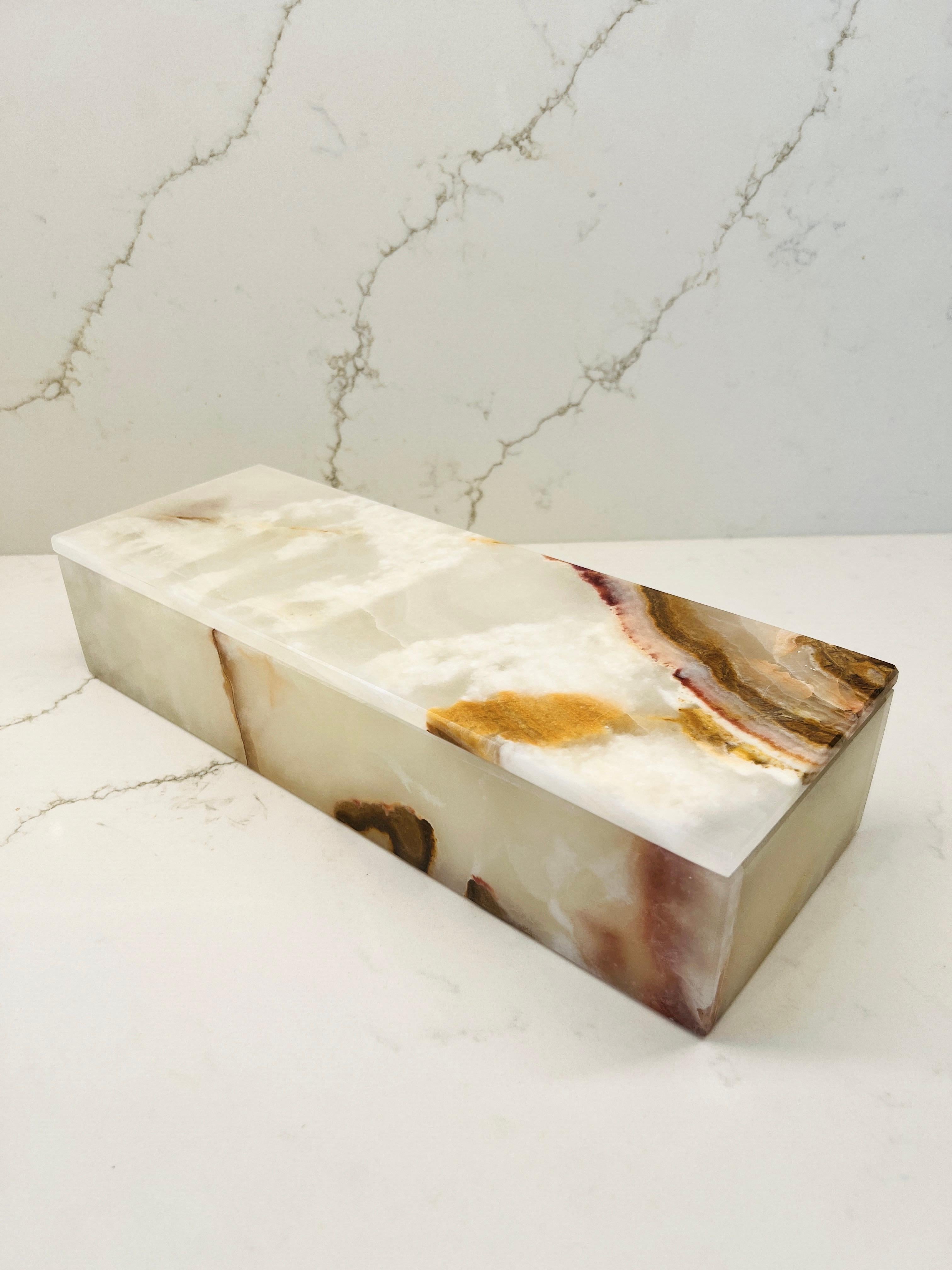 Large handcrafted box made of genuine white onyx stone with swirls of agate in rich hues of brown, tan, taupe, with occasional splashes of dark yellow and deep red. Lid has interior stoppers to keep from sliding out of place. Streamline design makes