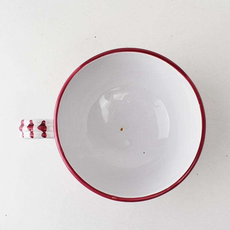 Une belle grande tasse à soupe peinte à la main avec anse, fabriquée en Italie. La poterie populaire italienne est devenue très convoitée ces dernières années. Cette pièce présente un motif floral rouge peint à la main sur fond blanc. La poignée est