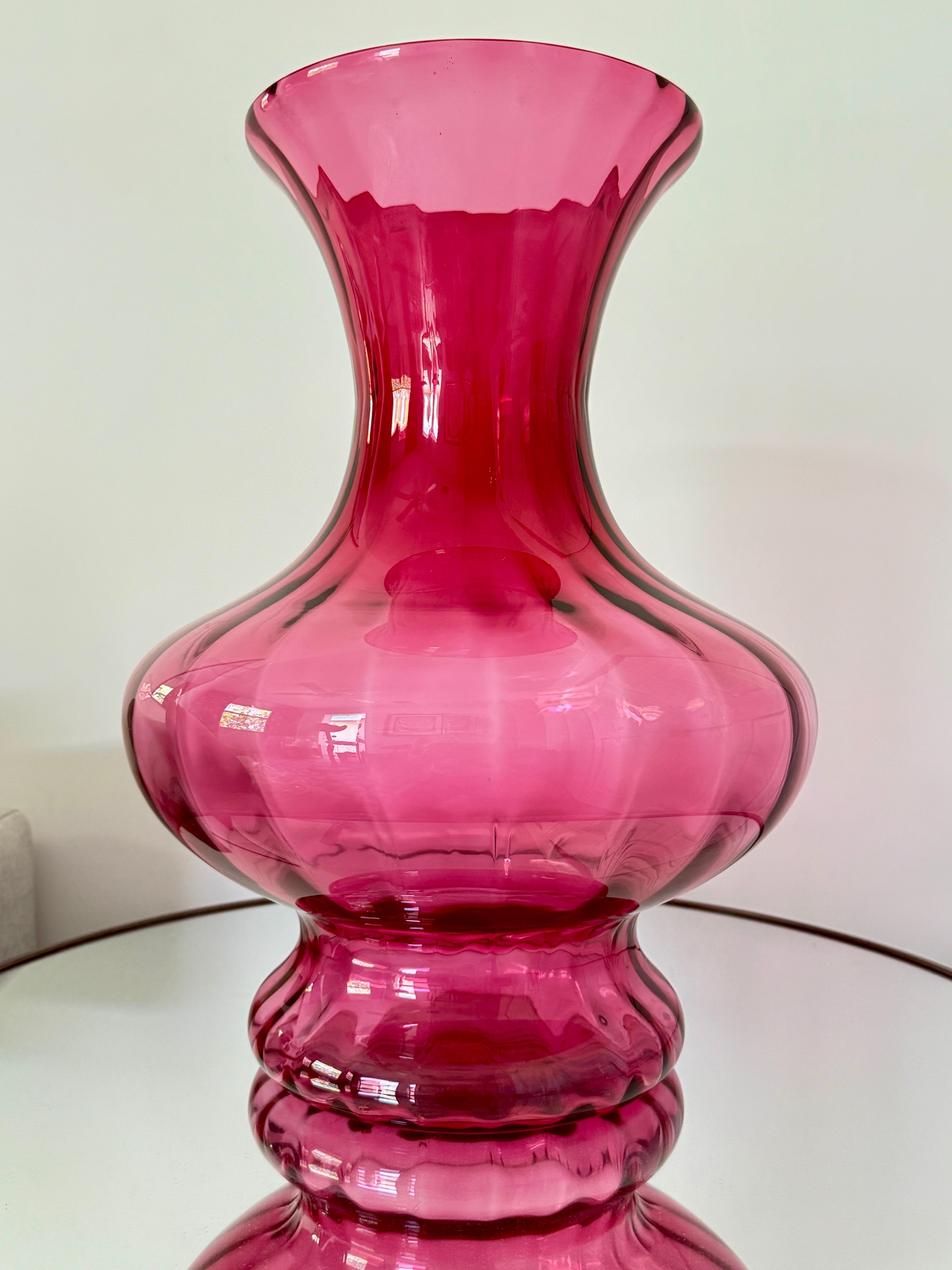 Large scale blown glass vase with fluted designs in hues of red violet.  The Post-Modern era vase features a wide stem that tapers, with a gorgeous bulbous center and a stylized footed base.  