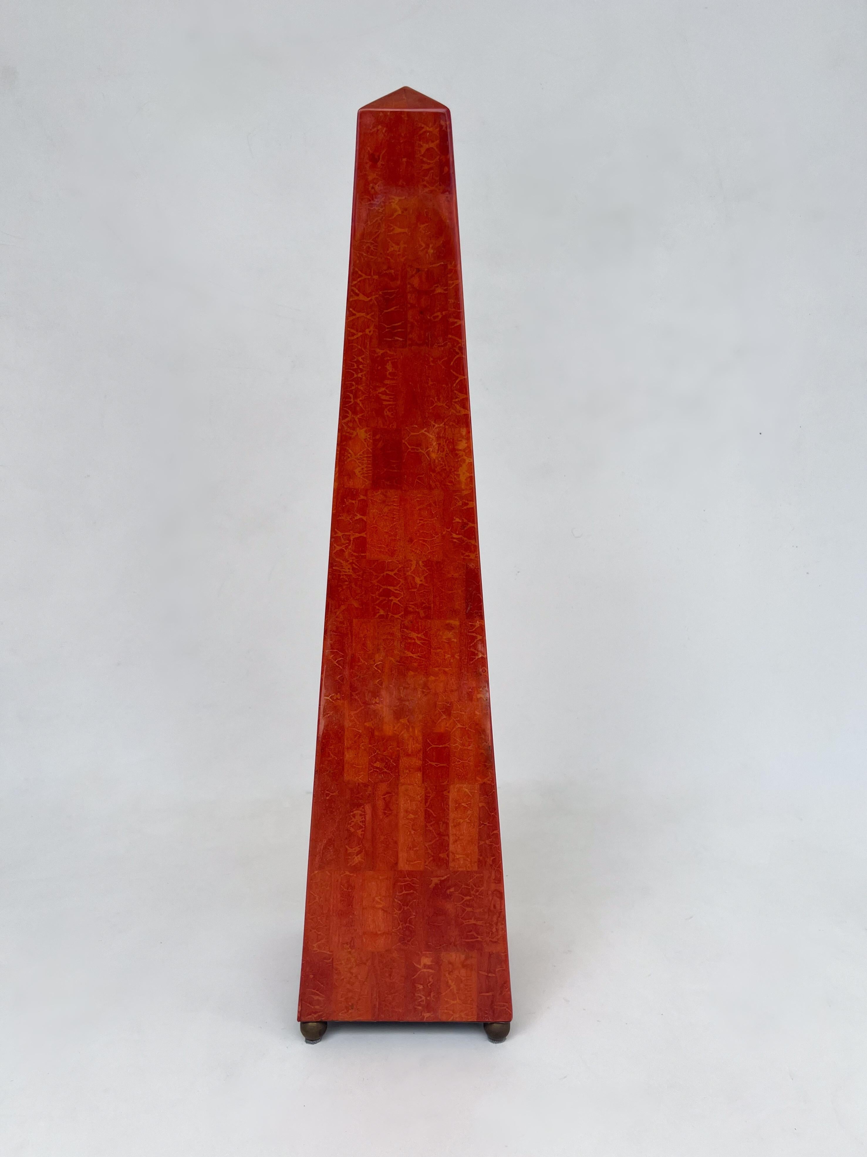Scultura obelisco in guscio di cocco rosso con piedi in ottone invecchiato di Maitland Smith del 1970. 
Costruito in legno rivestito di guscio di cocco rosso macchiato a tasselli e laccato chiaro con piedi rotondi in ottone invecchiato. 
In