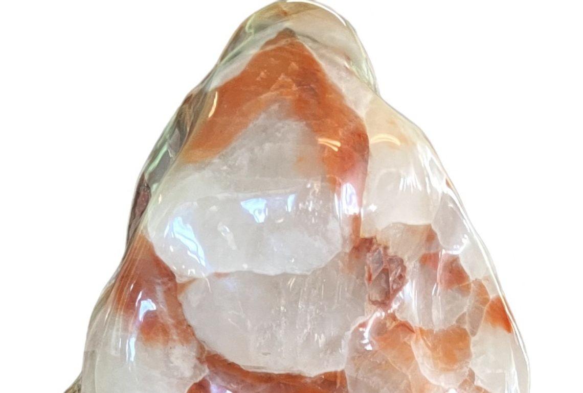 An impressive large red calcite stone displayed on a custom wooden base, showcasing the natural beauty of this richly hued mineral. The calcite features striking patterns and a deep crimson coloration, making it a visually captivating decorative