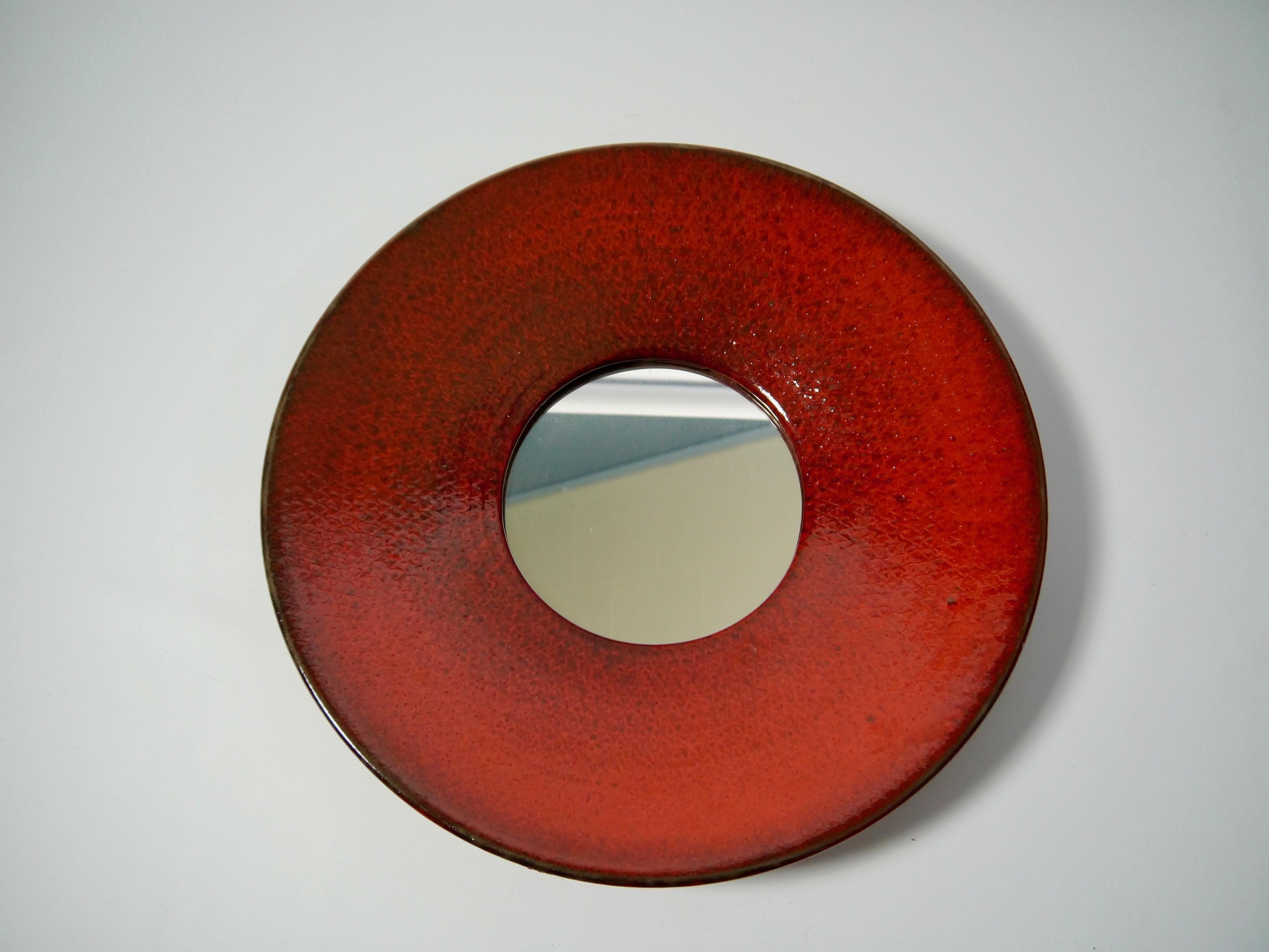 Rare ceramic wall mirror designed by Stig Lindberg for Gustavsberg. Signed with the studio hand and with Gustavsberg sticker. Deep red glazing with black hues.