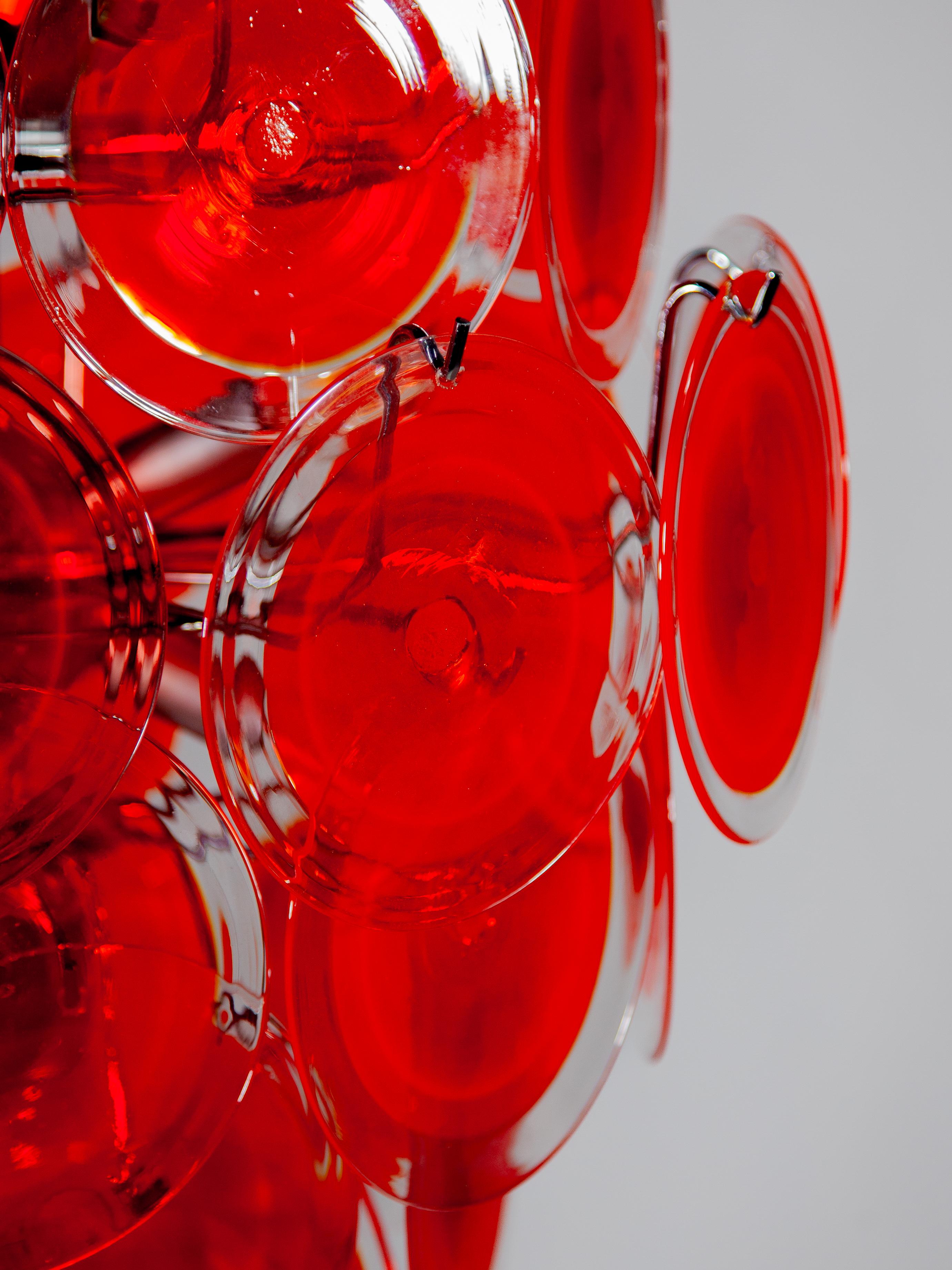 Very rare large original pre-owned red disk chandelier in perfect condition. See pictures in pre-owned setting. Hand blown art glass red and clear disks designed by Vistosi in the 60s Murano glass hanging on a metal chromed frame. The chandelier is