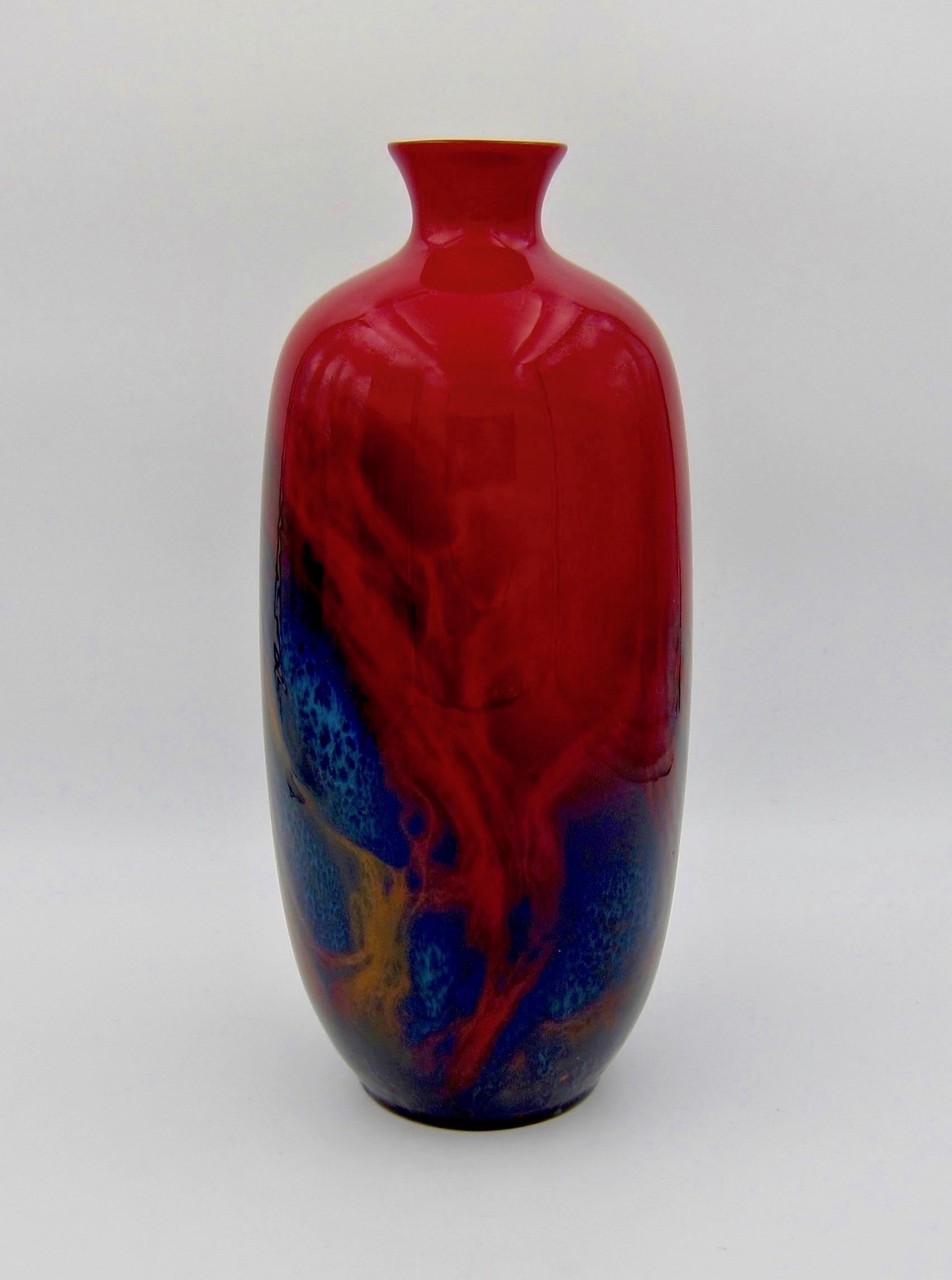 A large Royal Doulton flambé Art Deco vase, dating circa 1930. The English art pottery vase is enveloped in a high-fired flambé glaze of deep red shading to black and blue with fiery golden tendrils. Doulton's chief designer, Charles Noke