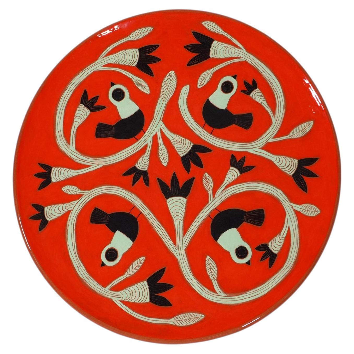 Large red glazed dish with black and green birds by Beatriz Garrigo, 2023