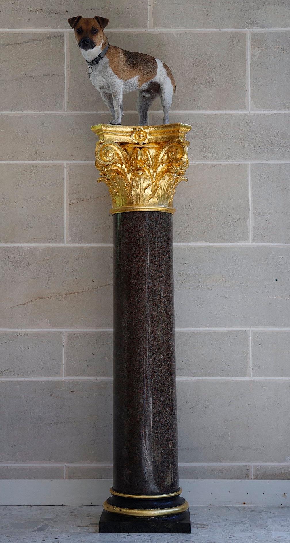 Große Säule aus rotem Granit und patinierter Bronze im neoklassizistischen Stil mit korinthischem Kapitell. Sie steht auf einem runden, abgestuften Sockel über einem quadratischen Sockel. Französisches Werk des 20. Jahrhunderts.

