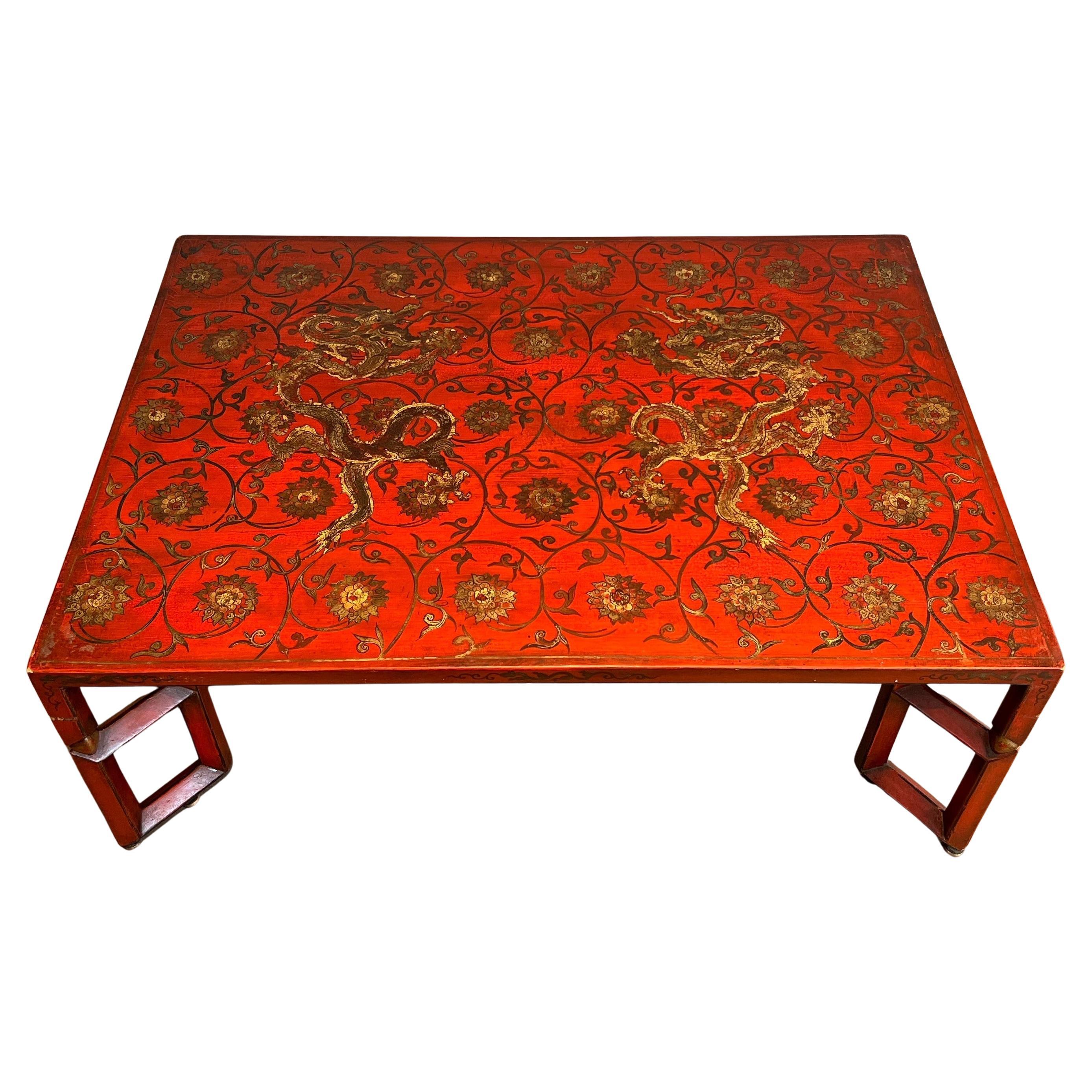 Grande table basse laquée rouge avec décorations chinoises en or