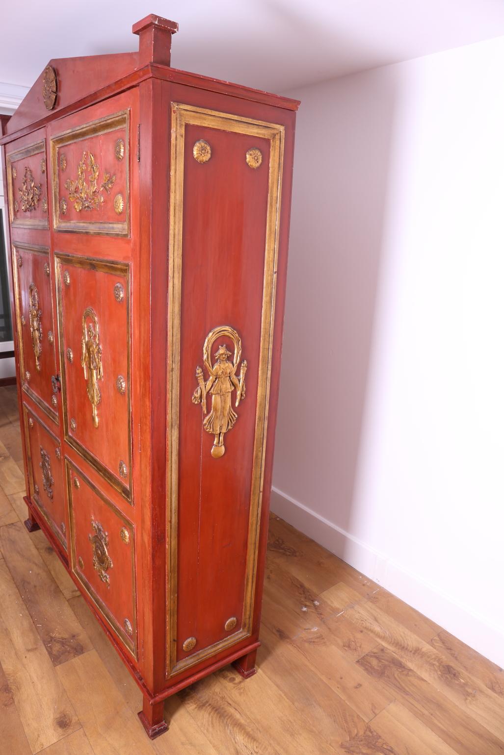 Egyptian Revival Large Red Lacquered wardrobe with gilded figures in relief For Sale