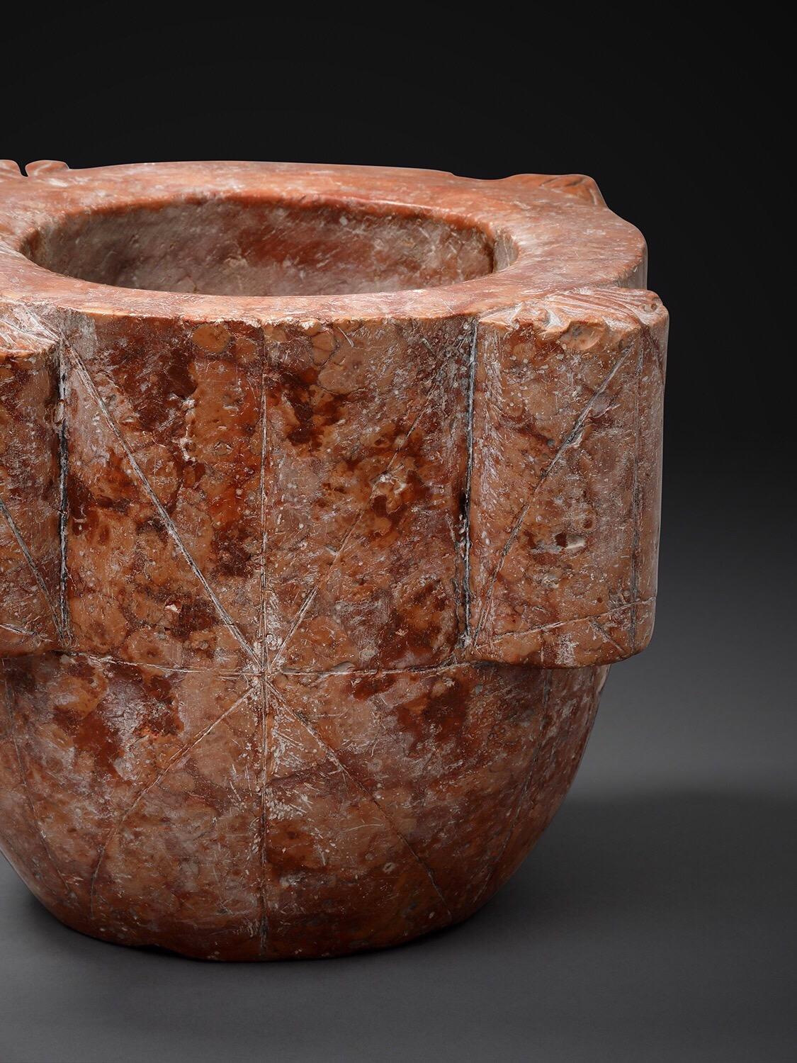 This uniquely beautiful mortar was carved from a solid block of red Verona marble (Northern Italy). On the surface of each of the four handles is carved a flower-like design. Mortars were used in the kitchens or in apothecaries to crush the herbs