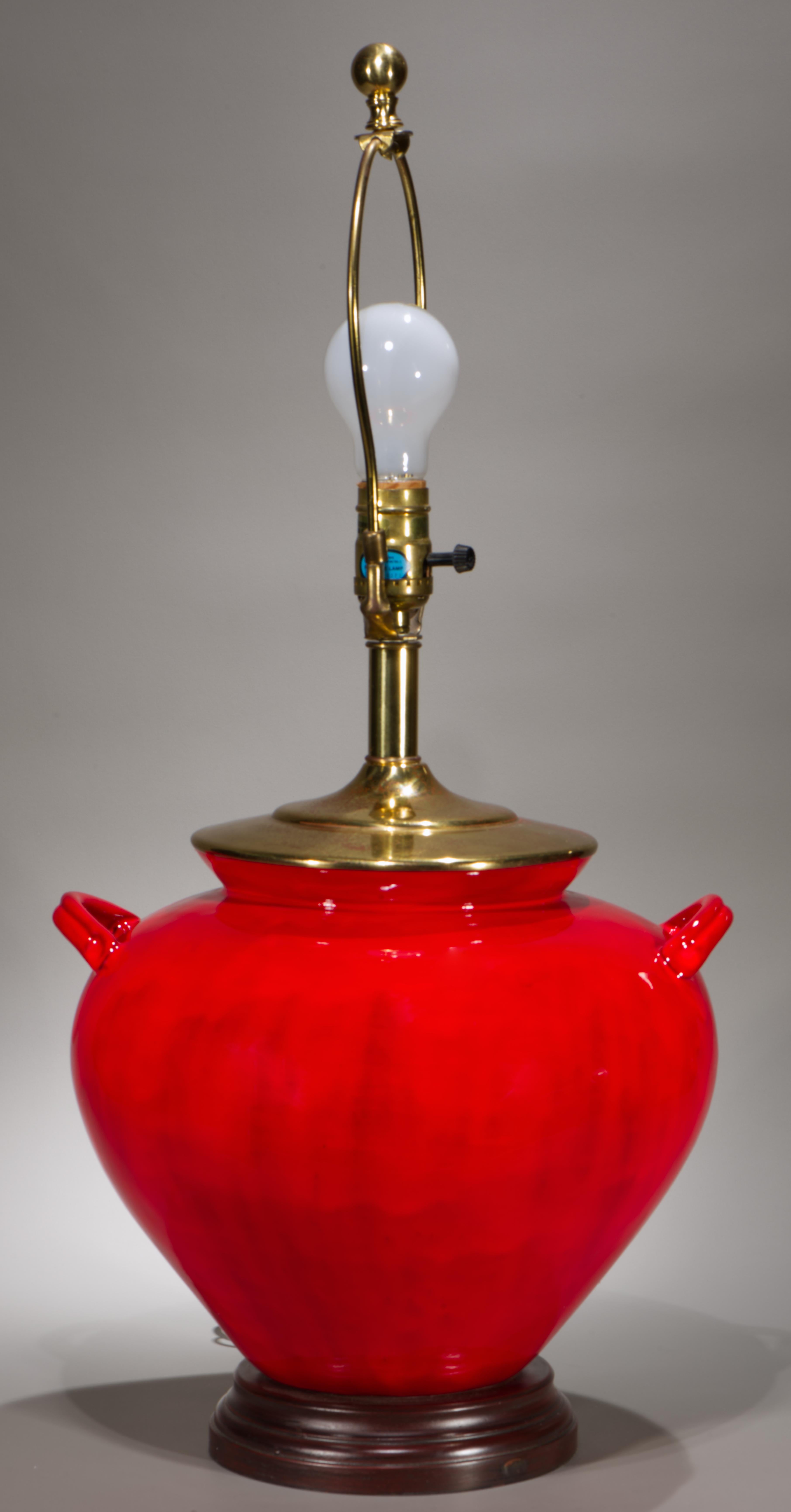 Vintage-Tischlampe mit großem, skulpturalem, urnenförmigem Keramik-, Porzellan- oder Töpferkörper, verziert mit leuchtend roter oxblood Glasur. Die Leuchte ist auf einem runden, abgestuften Holzsockel montiert und mit Messingbeschlägen versehen, die