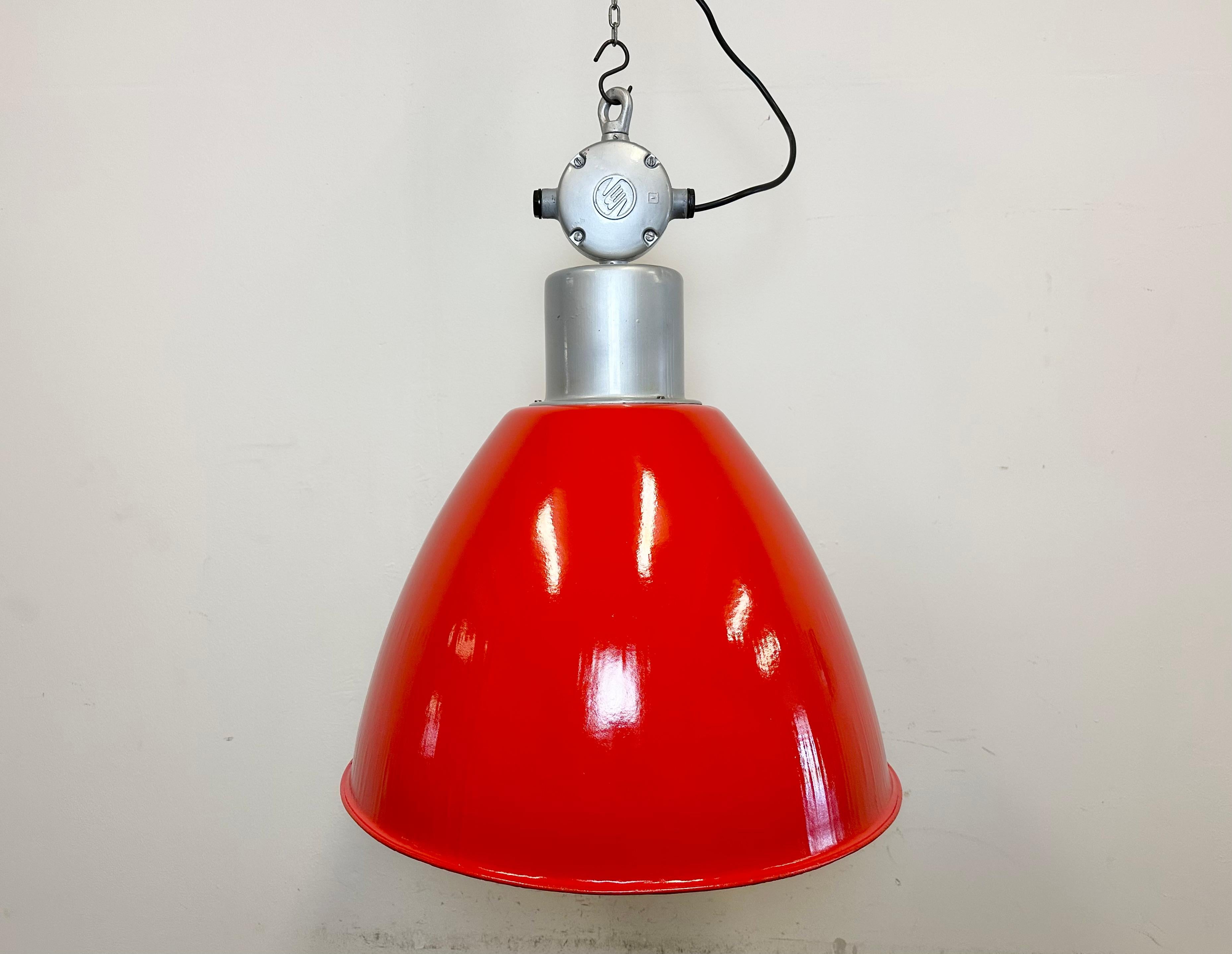 This Industrial pendant light was designed in the 1960s and produced by Elektrosvit in the former Czechoslovakia. It features a silver cast aluminium top, a newly painted shade on red with an original white enamel interior.
New porcelain socket