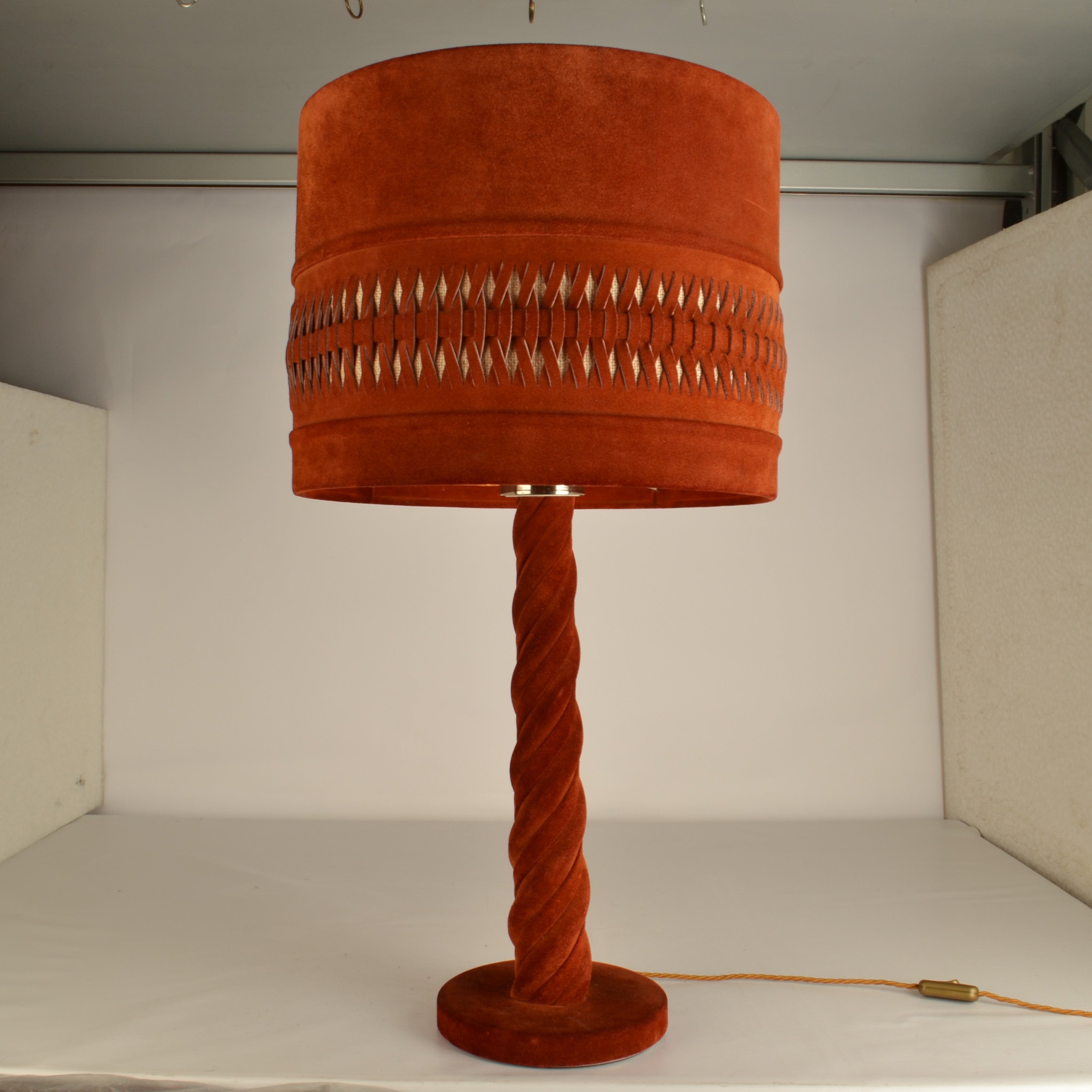 Tall suede 1960's table lamp in burned Siena red . This rare hand made suede shade party sild and woven into a pattern that reveals the linen backing, creating a warm atmospheric light. The stem is twisted, the base and stem are covered in the same
