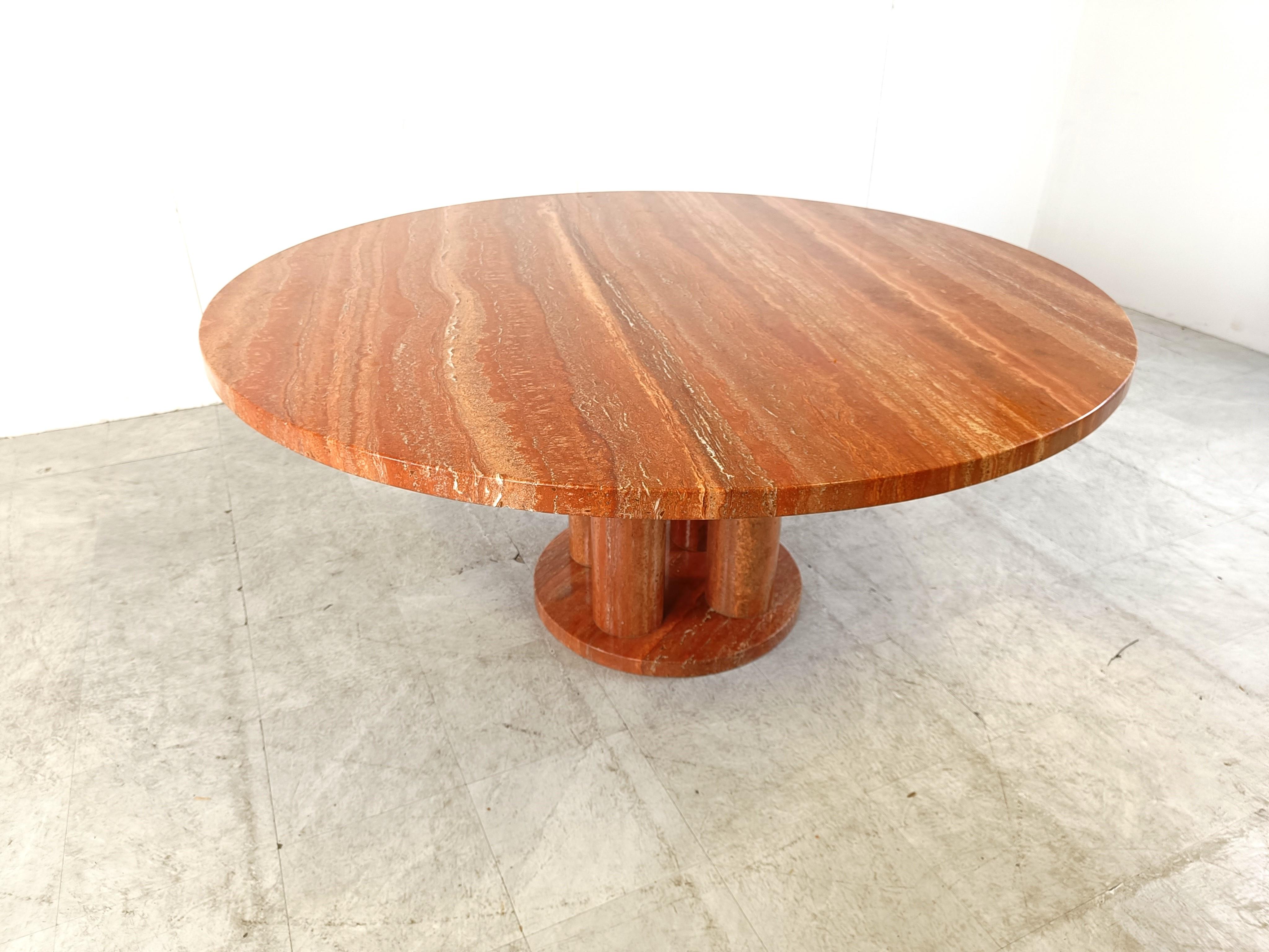 Remarkable red travertine dining table with a four piece column base and a large round table top.

The table was custom made in the 1970s, it's very much in the style of Mario Bellini.

Beautiful natural red granite stone with a gorgeous natural