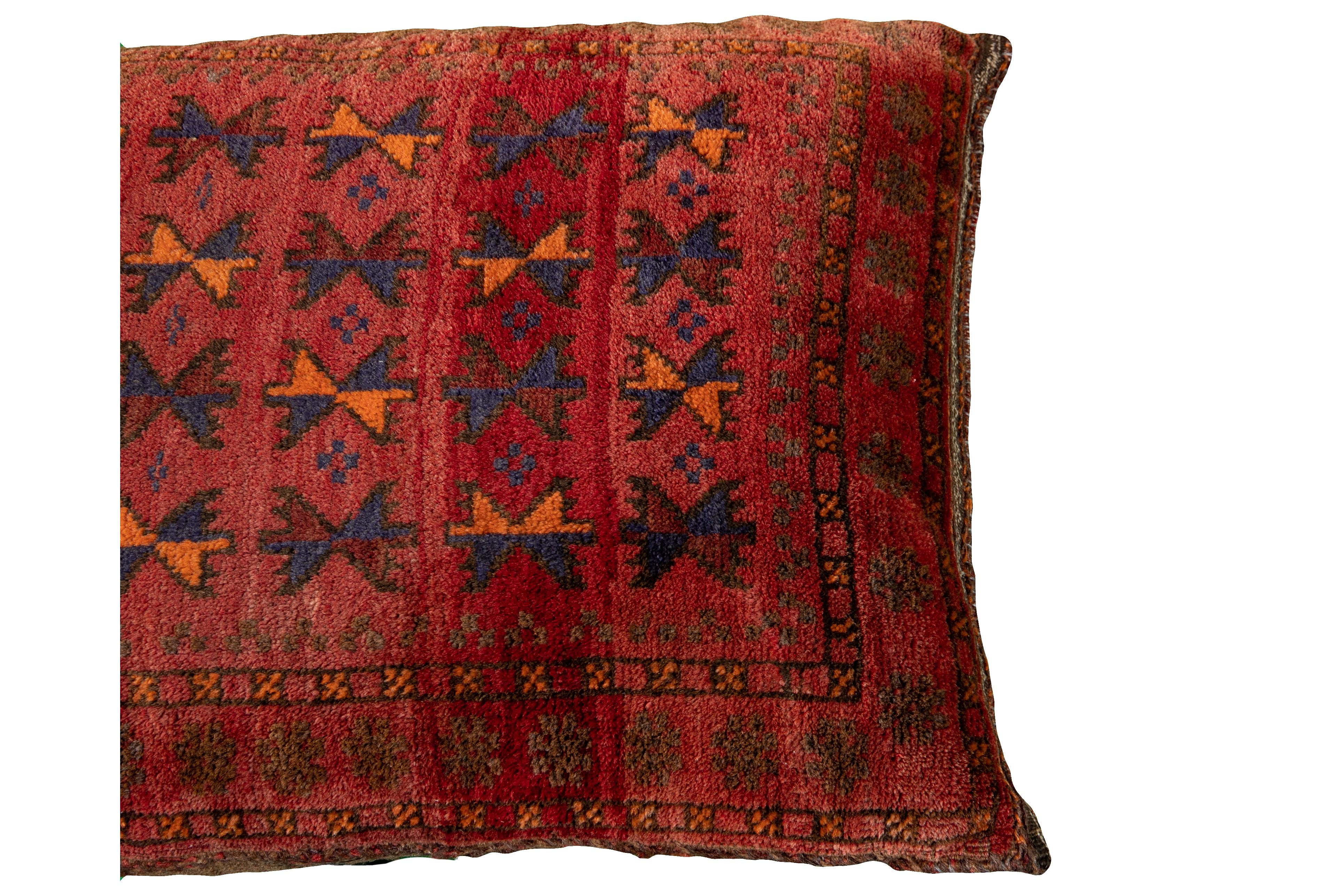 Beautiful vintage Persian Turkmen handmade pillow with a red field. This Persian Pillow has accents in orange and blue. This Turkmen Pillow features a Vintage take on a Classic design motif in vibrant colors to produce a vigorous experience of