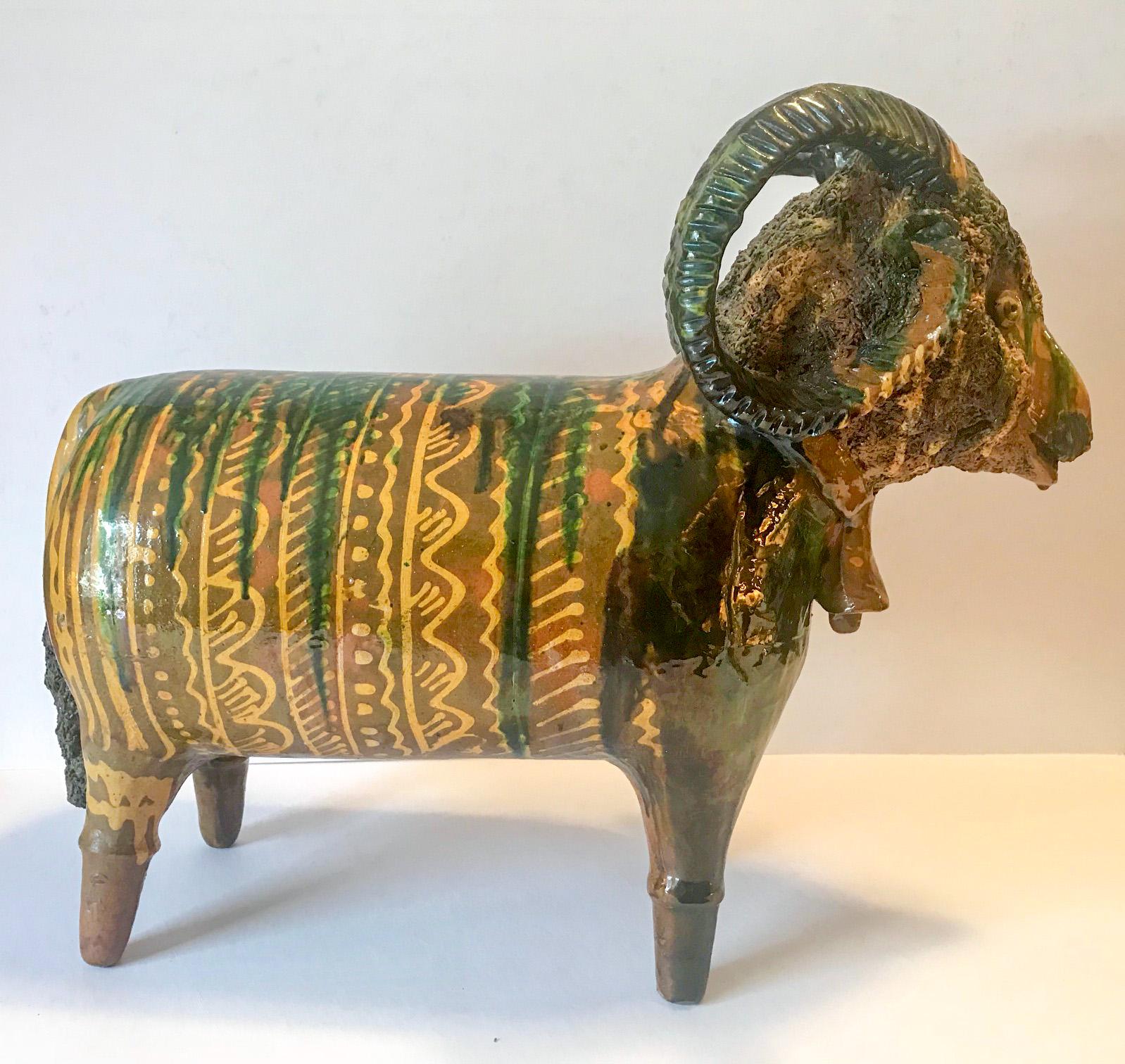 Large-sized redware figure of a ram with unknown origin. Mid-century, hand modeled ram with hollow body. Heavy applied spaghetti wool, applied tail and curled horns. Monogram and date incised underneath. The rams surface is covered in a brown,