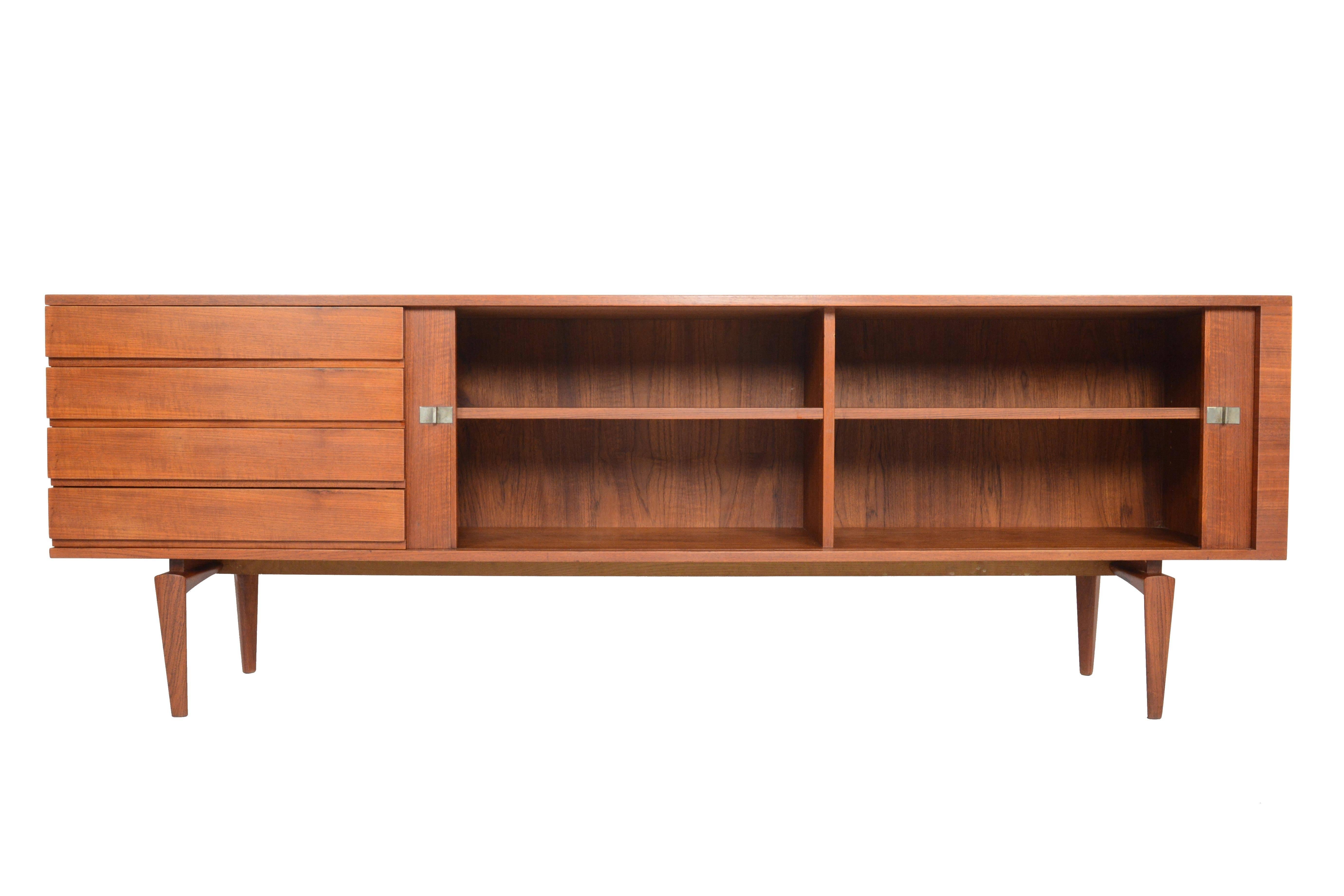 This gorgeous Danish modern tambour door credenza in teak was designed by H.W. Klein for Bramin in the 1960s. This stunning piece will be the highlight of any midcentury collection, offering two large tambour doors with steel pulls. The interior