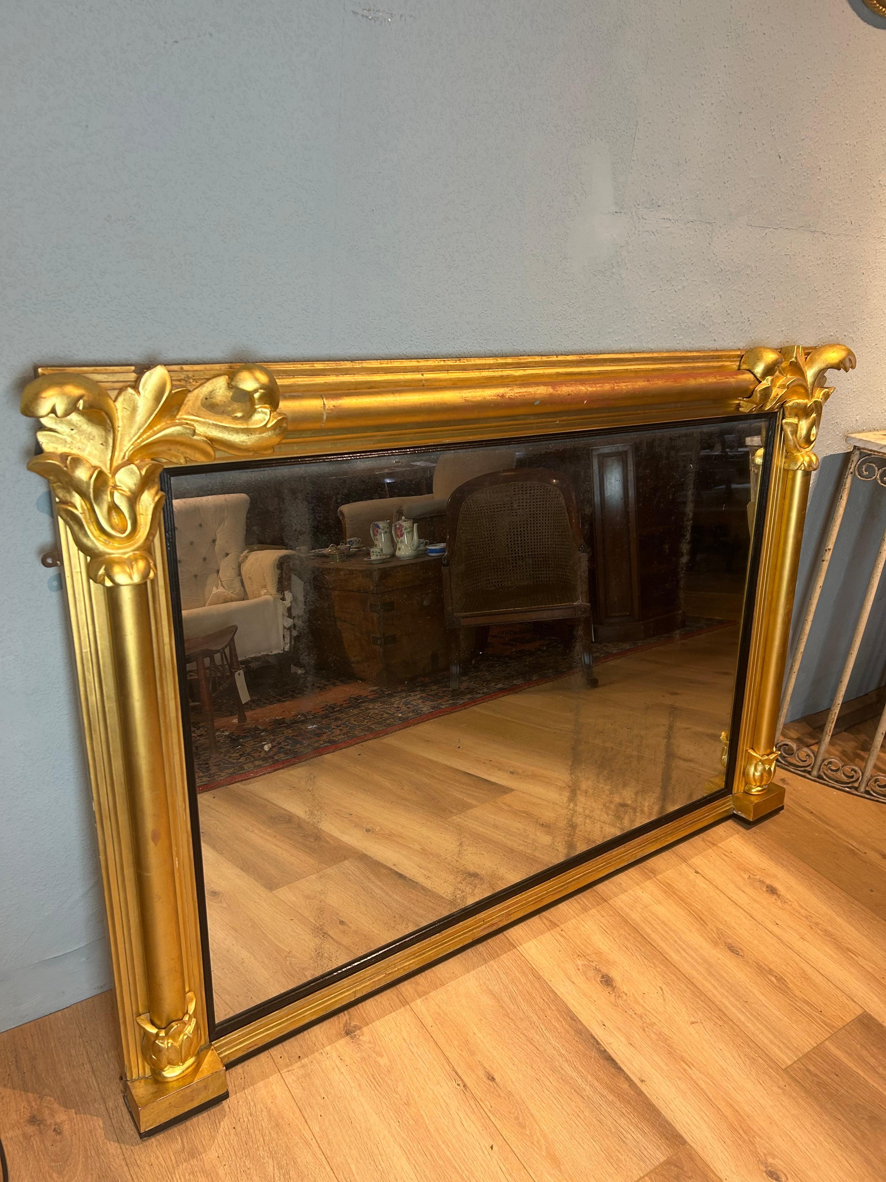 Gran espejo dorado inglés Guillermo IV Overmantel circa 1830, el marco dorado está bordeado con columnas torneadas de media caña y decoración de hojas talladas en las esquinas superiores, rematadas con hojas de acanto. Este impresionante espejo
