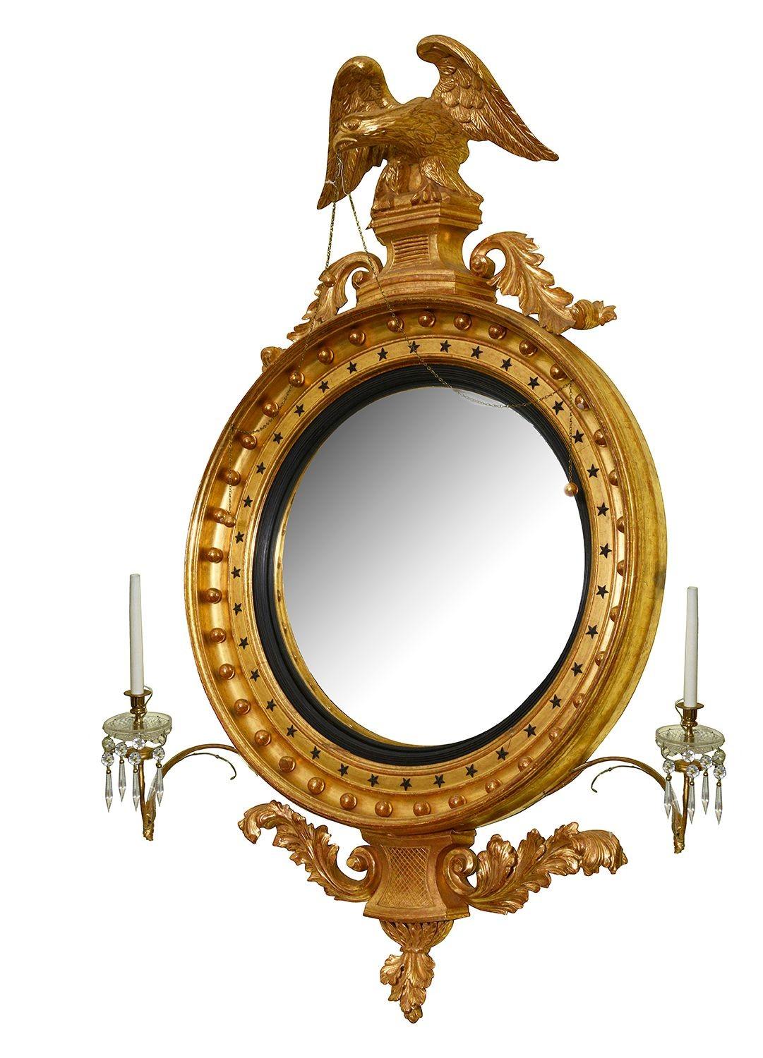 Este asombroso espejo de pared convexo de madera dorada tallada de la época de la Regencia mide unos impresionantes 100 cm de alto y hace gala de una artesanía y una opulencia exquisitas. El marco ornamentado del espejo presenta tallas intrincadas y