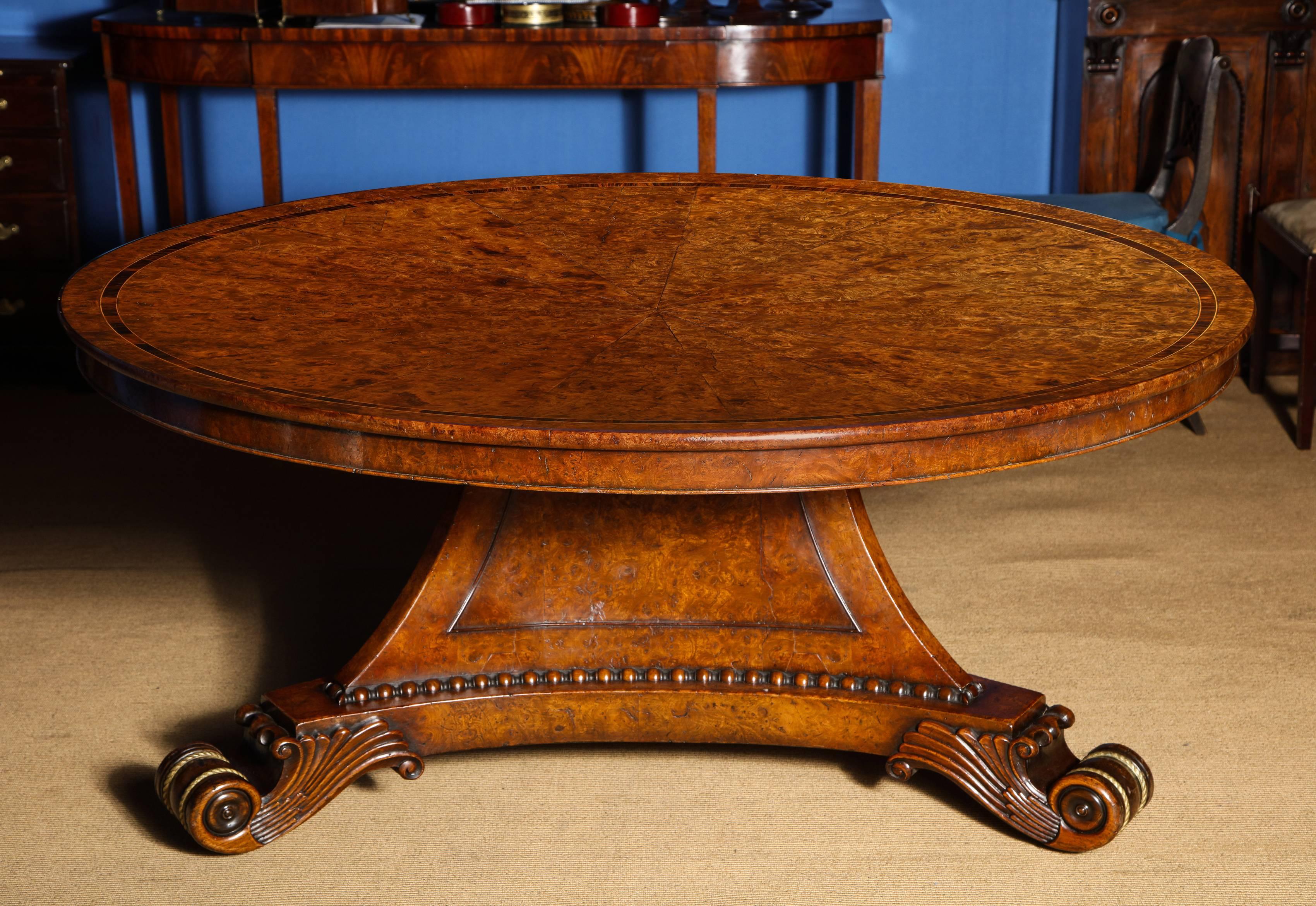 Very Fine Large Regency Period Round Pollard Elm Tilt Top Center Dining Table, the circular top with 16 sunburst figured veneers and having rosewood cross-banding and box and hare-wood line inlays with a rounded edge and narrow apron, the three