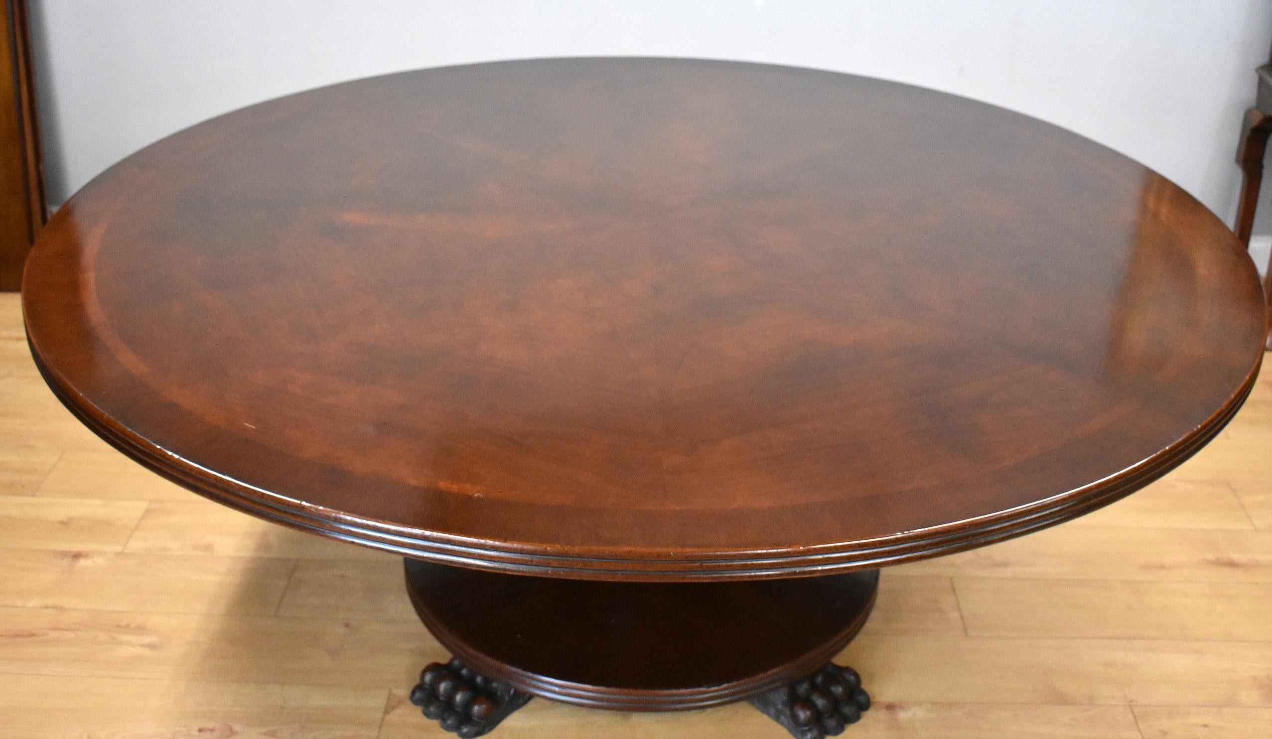 Large Regency style mahogany circular dining table with radial veneers to the top with starburst figured mahogany to the centre. The table stands on a turned column with circular base with large paw feet. Would seat 8 comfortably.