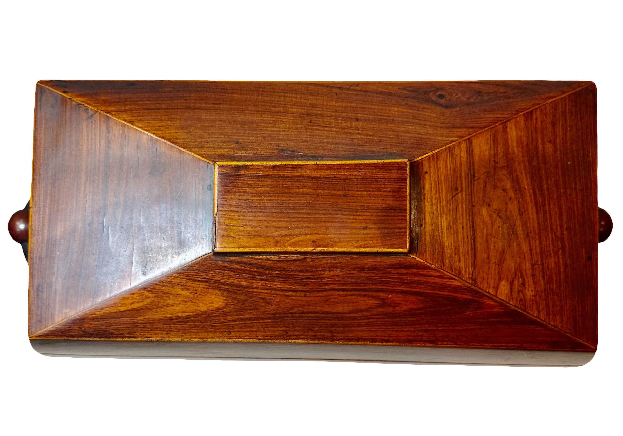 A rather large and wonderful mahogany regency tea caddy. It is trimmed out with an inlay and an ivory keyhole. The interior is four inches deep in the tea compartments, does not have original glass. Each compartment is two and a half by four and