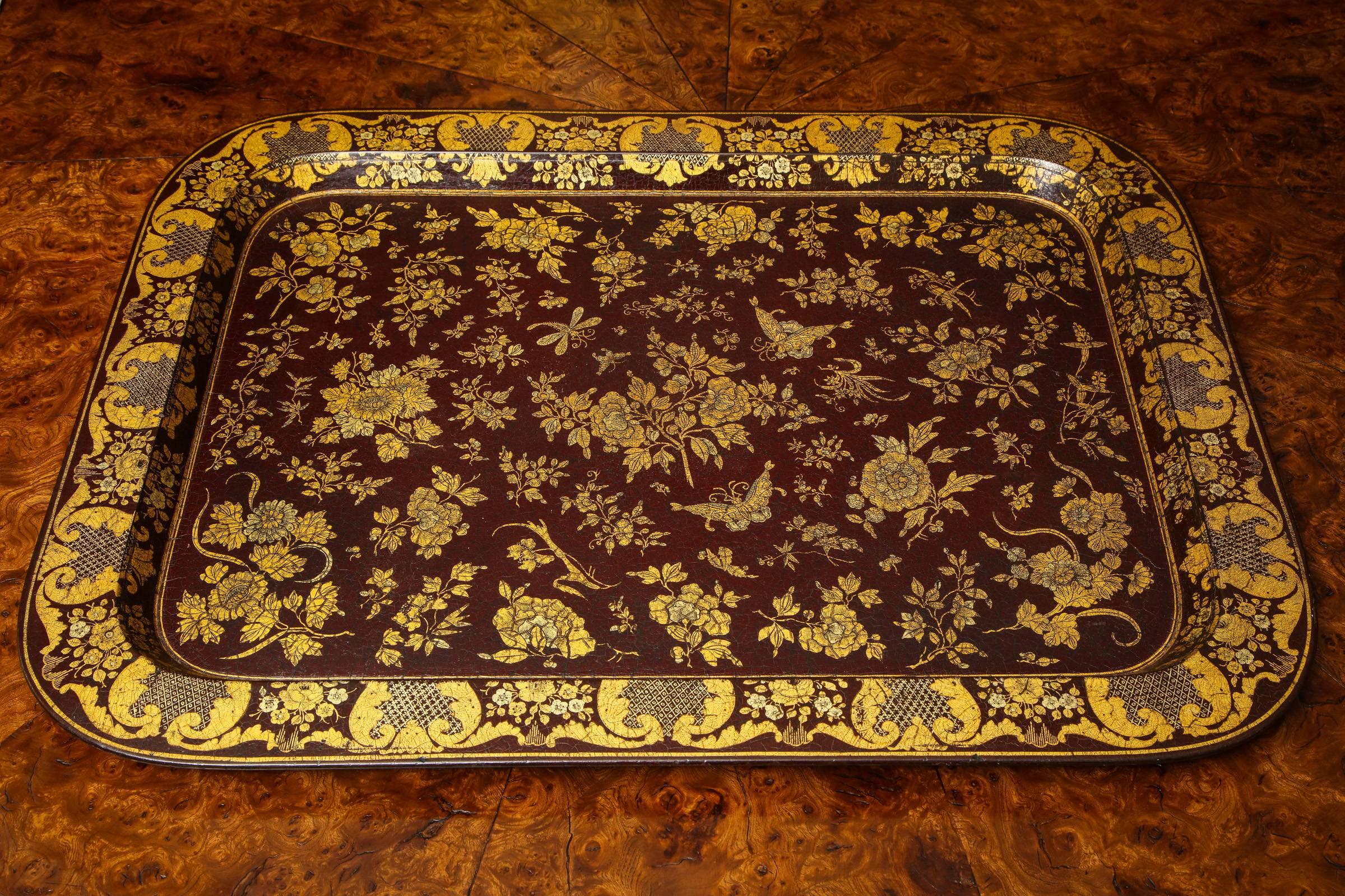 Fine large Regency wine colored papier mâché rectangular dished tray, decorated with butterflies, flora and fauna in gold and silver, English, circa 1830. This tray can be mounted as a tray table at our cost.

Measures: Height 1
