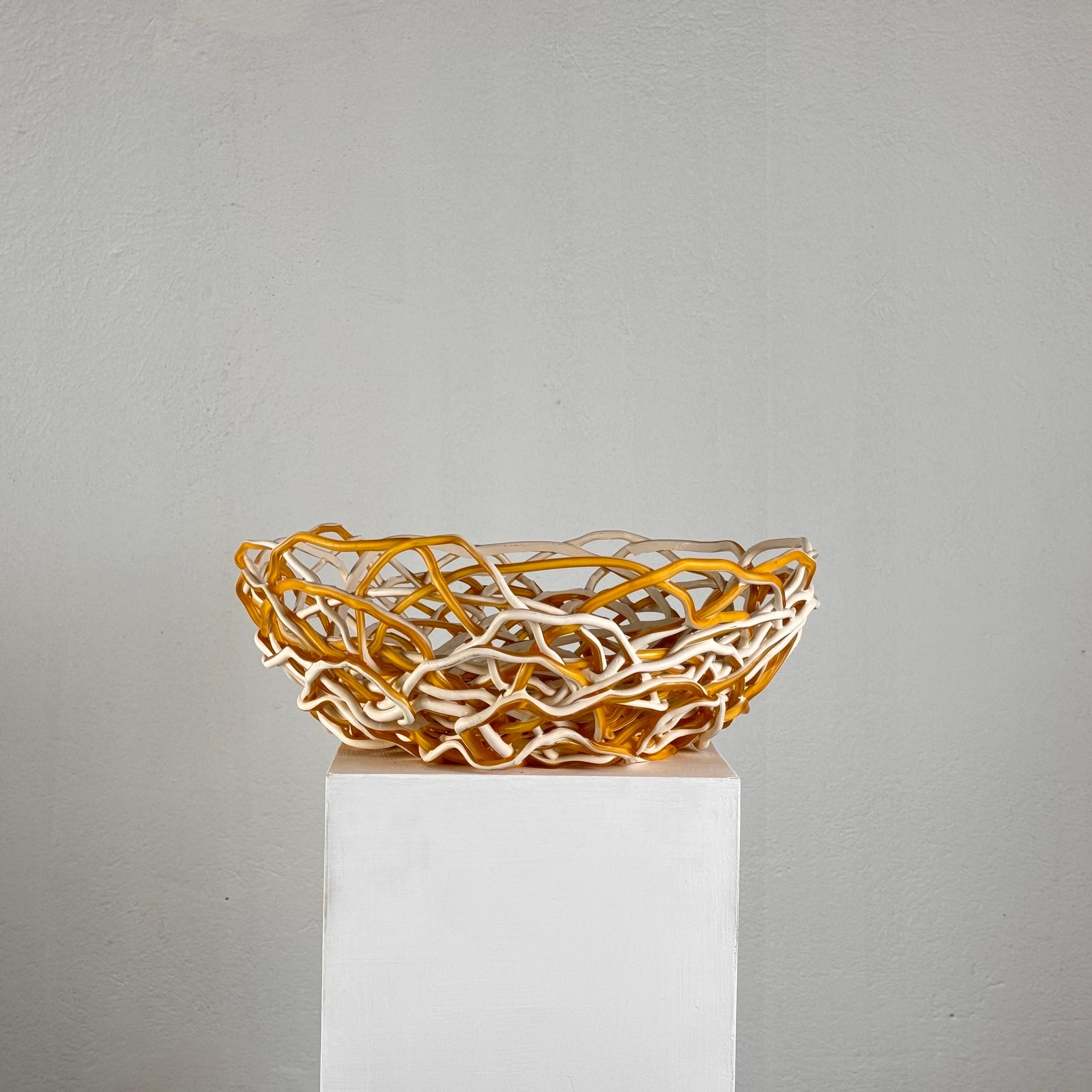 Ce superbe grand bol, conçu par Gaetano Pesce pour Fish Design en 2012, est un exemple vibrant de design italien contemporain. Fabriqué en résine de haute qualité, le bol présente un mélange accrocheur de blanc et de jaune, incarnant le style
