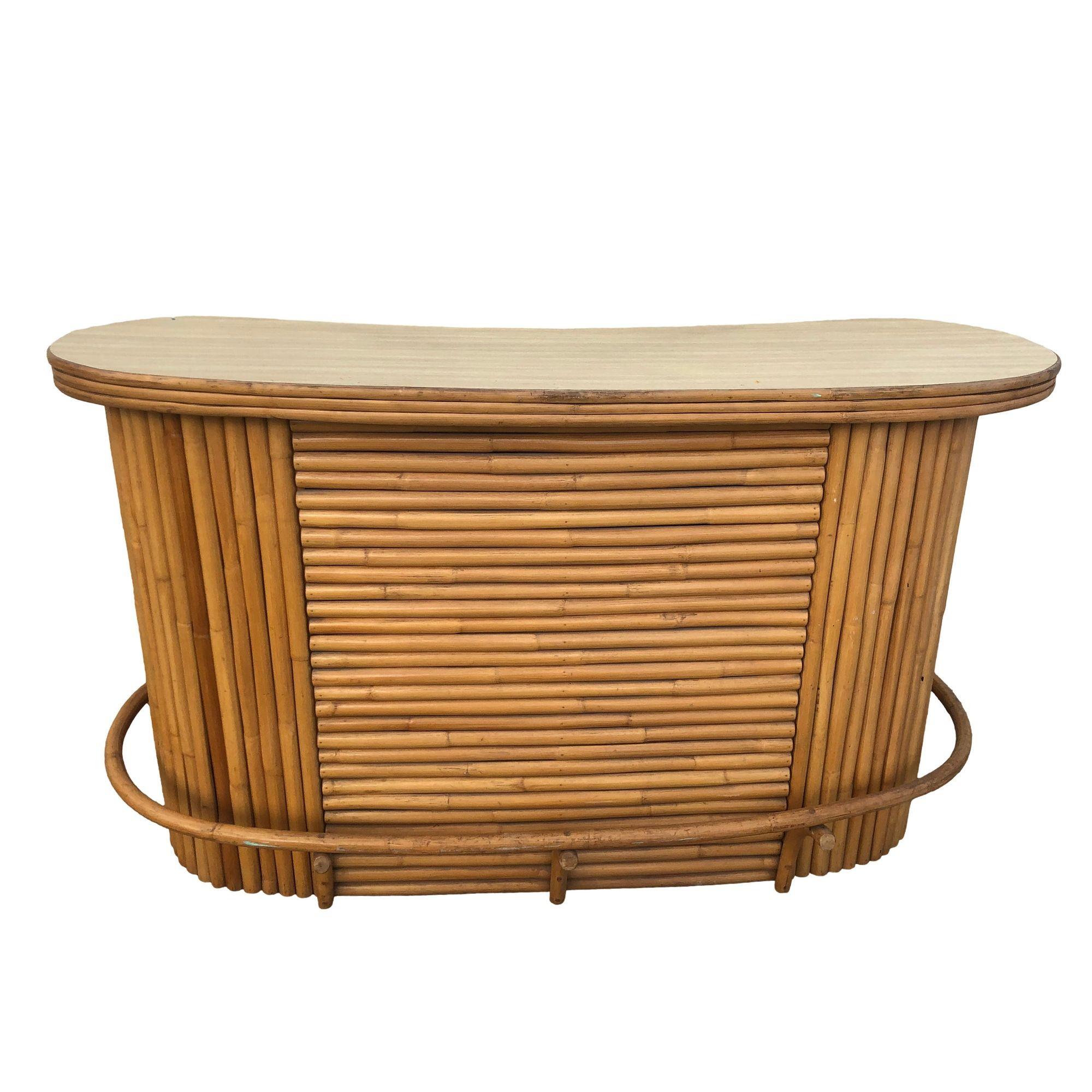Experience vintage charm with our restored rattan bar featuring a sleek Formica top. This exquisite piece seamlessly blends Mid-century era styling with Hawaiian charm. The front is constructed with a mix of vertically and horizontally stacked