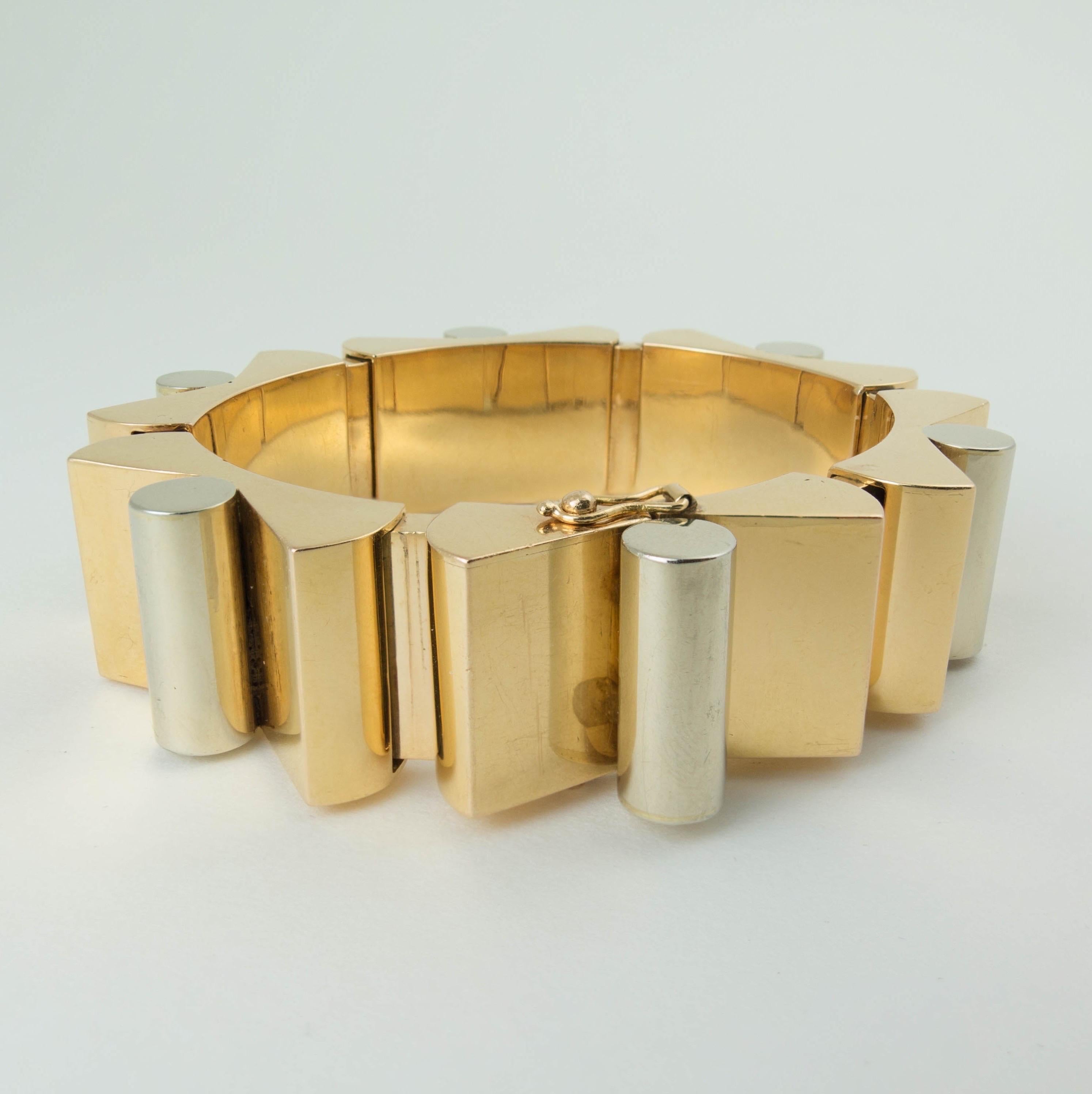 An impressive sculptural two tone 18k gold Retro tank bracelet with French assay and import marks, circa 1940's. 
The 18k yellow and white gold tank bracelet embodies Machine Age design, with its chunky, geometric links that are industrial,