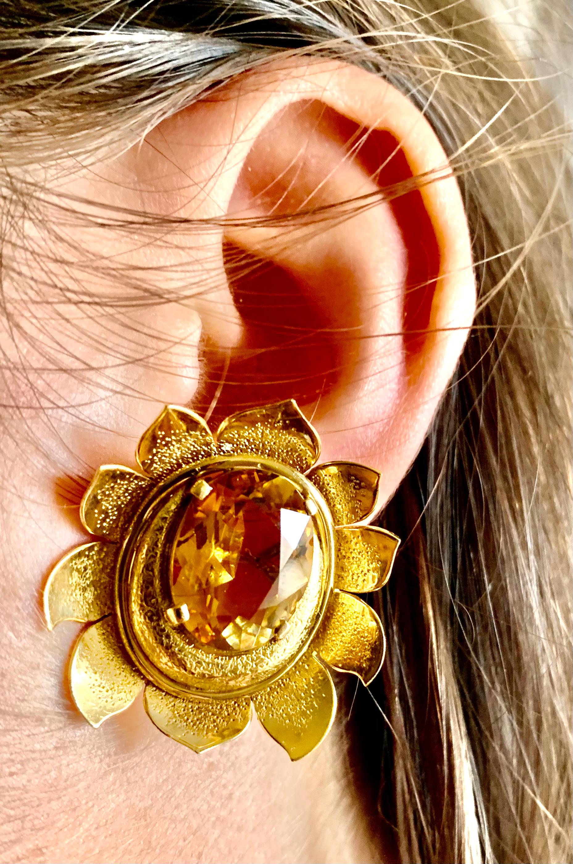 Fabulous estate faceted citrine and textured 14K yellow gold flower earrings. The lively vibrant oval citrine gemstones measuring 16mm by 12mm set dramatically within a beautiful detailed flower form setting. Original, bespoke design from the