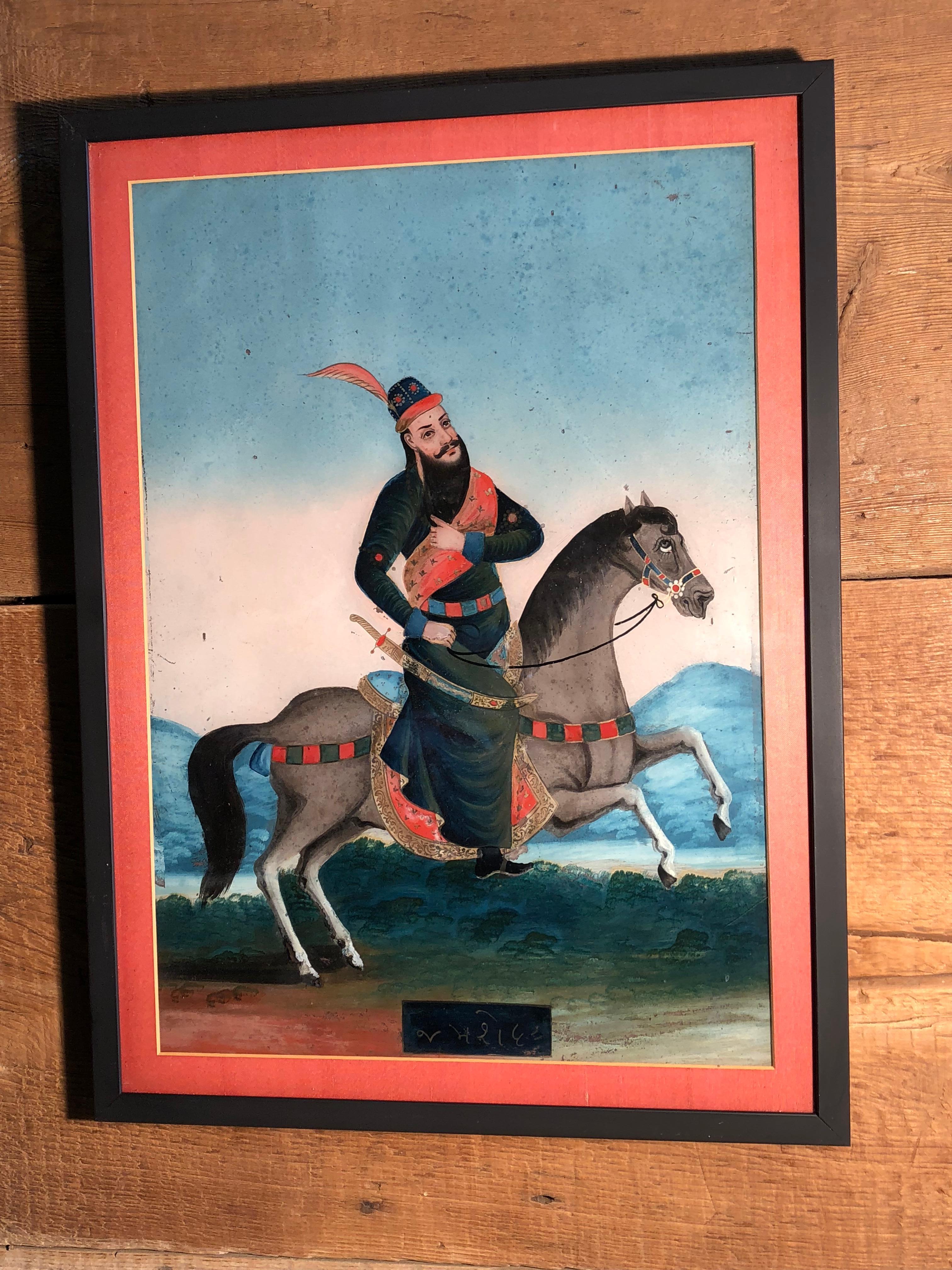 A large églomisé portrait of a Moghul prince on horseback, in a landscape, early 19th century, Rajasthan, India. These large portraits are very rare due to age and fragility.