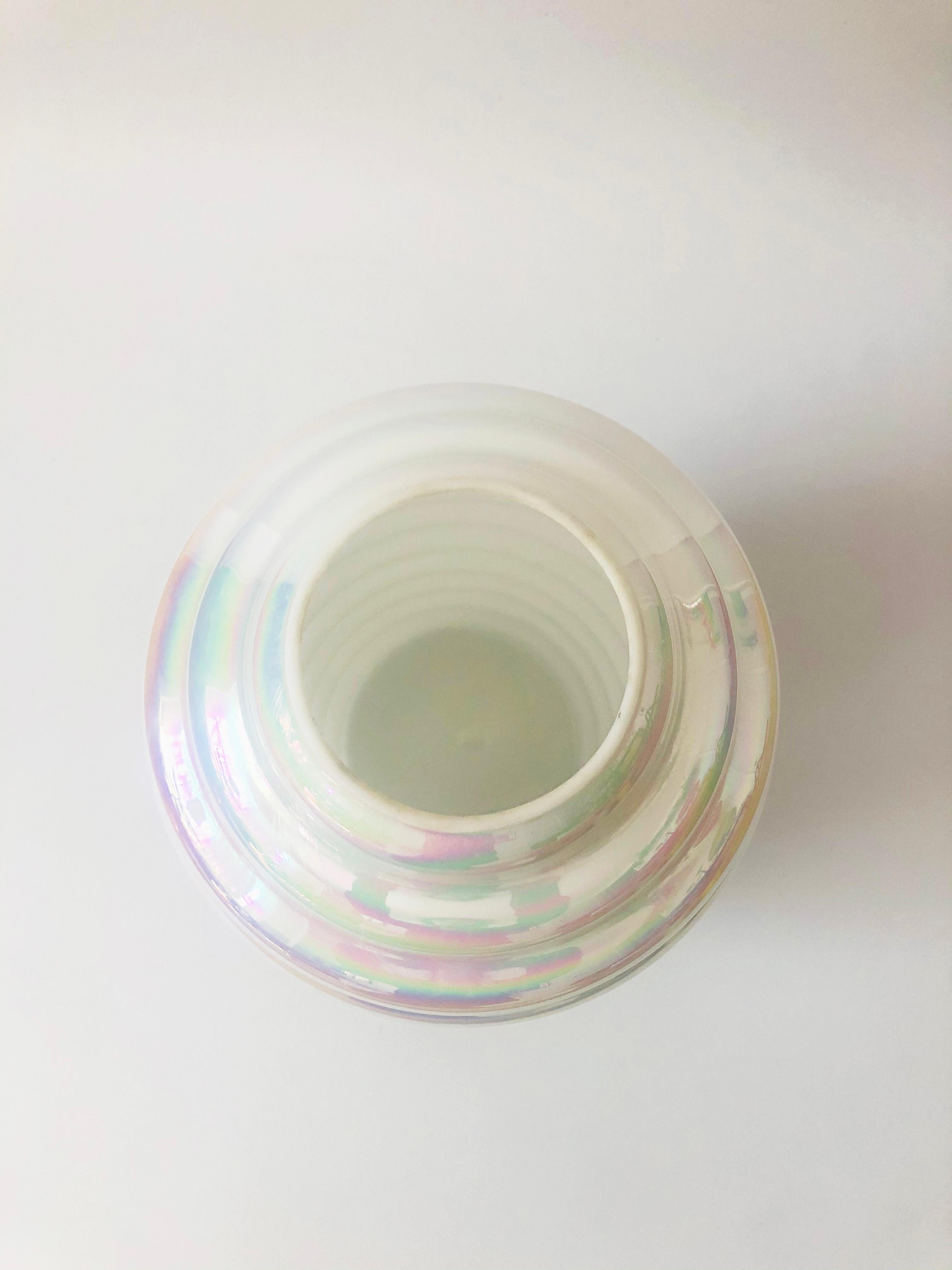 A large vintage hand blown glass vase. Beautiful opaque white iridescent coloring throughout in a unique ribbed shape. Made by Cambridge Glass.