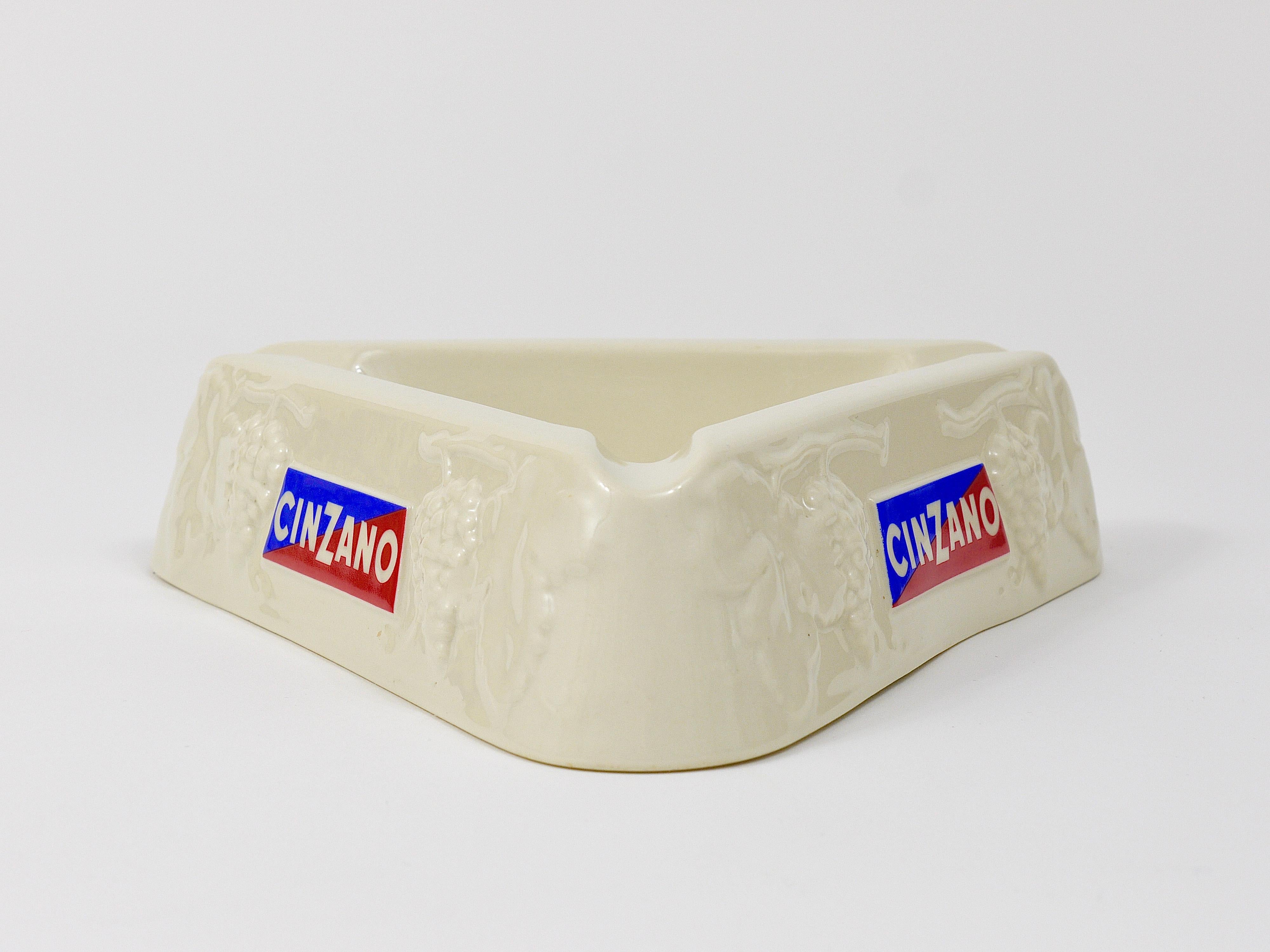 A beautiful and decorative triangular midcentury Cinzano Vermouth ashtray from the 1950s, executed by Richard Ginori, Italy. Made of
china with a shiny off-white glaze and a lovely wine grapes relief pattern and the Cinzano Logo on all three sides.