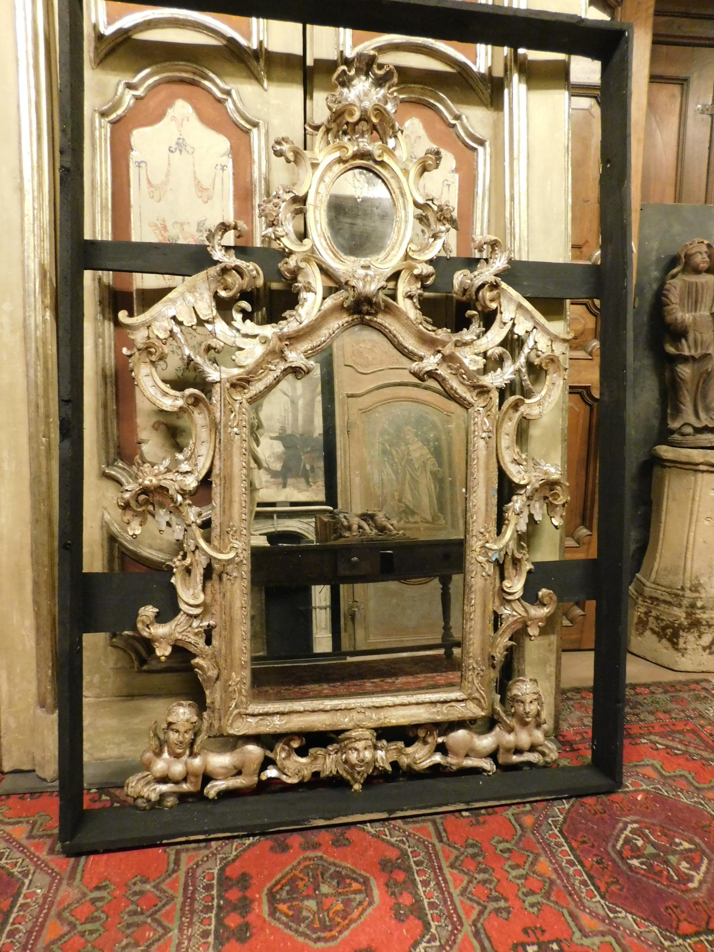 Ancien et grand miroir, richement sculpté à la main et à la feuille d'argent, avec double miroir et des représentations de créatures mythologiques sculptées dans le bois du cadre, construit pour le positionner au-dessus d'une importante cheminée