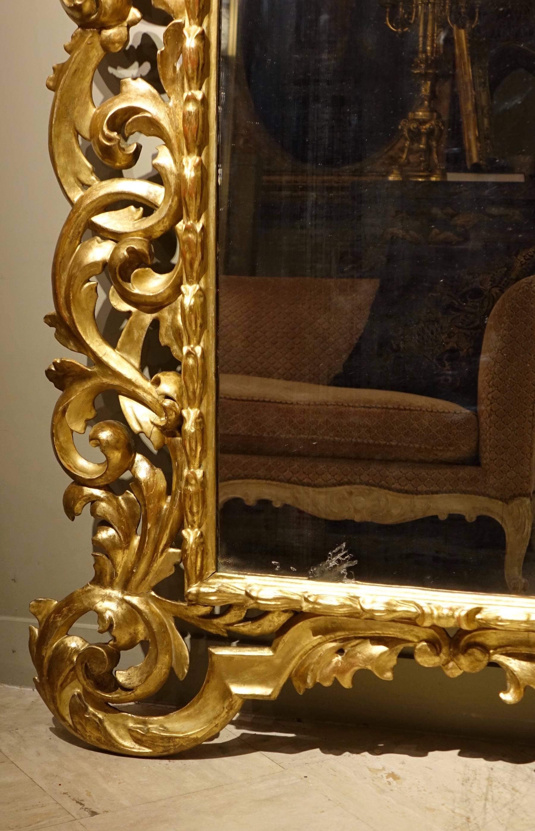 Large richly carved giltwood mirror with rich scroll patterns and foliage.
Beautiful mercury central glass.
Good condition, Italy, 18th century.