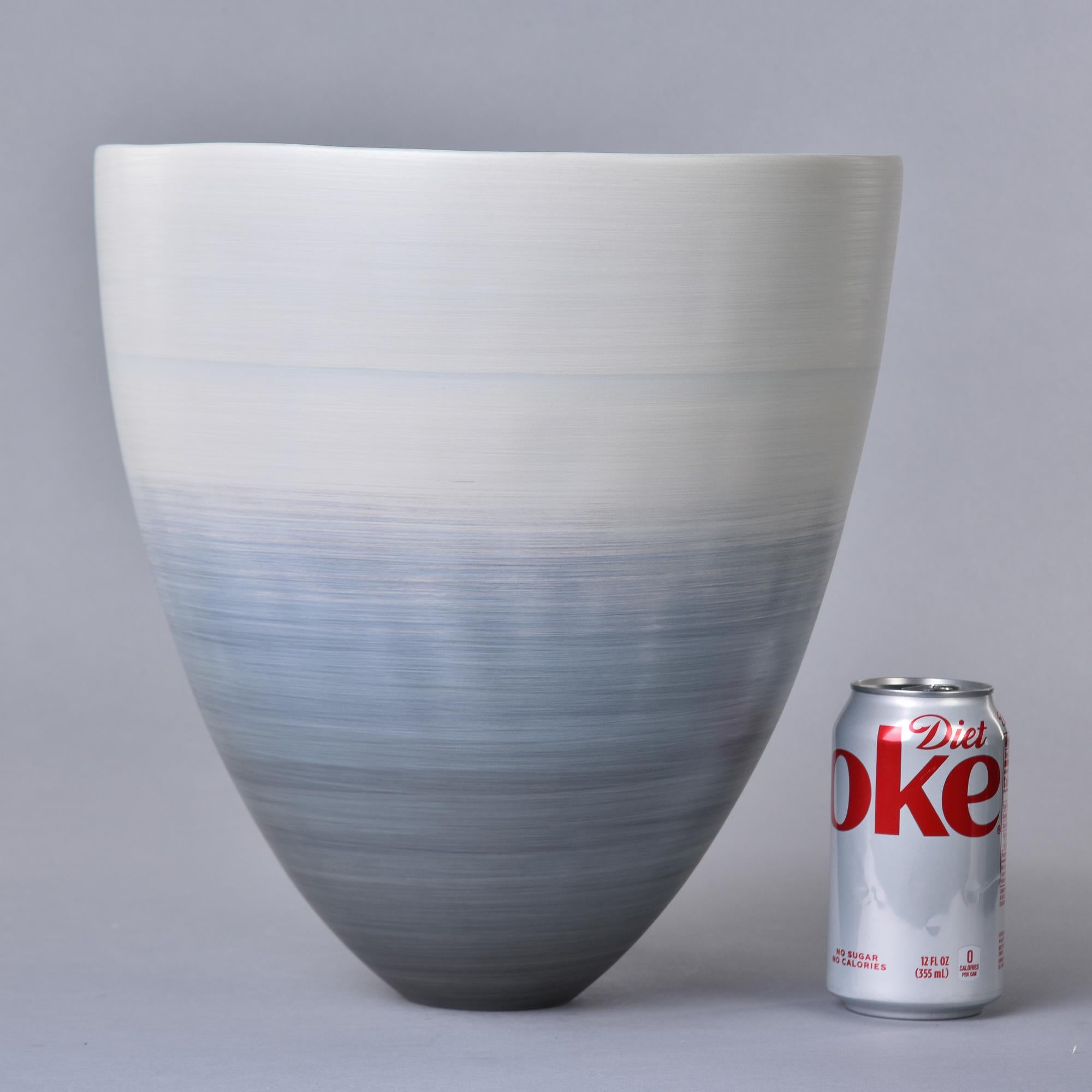 New and hand made in Italy by Rina Menardi, this cup-form bowl or vase stands 12” tall and has an ombre style glaze in shades of blue/gray. Streamlined shape with thin, glazed porcelain walls and an ombre glaze on the inside. Signed by the maker on