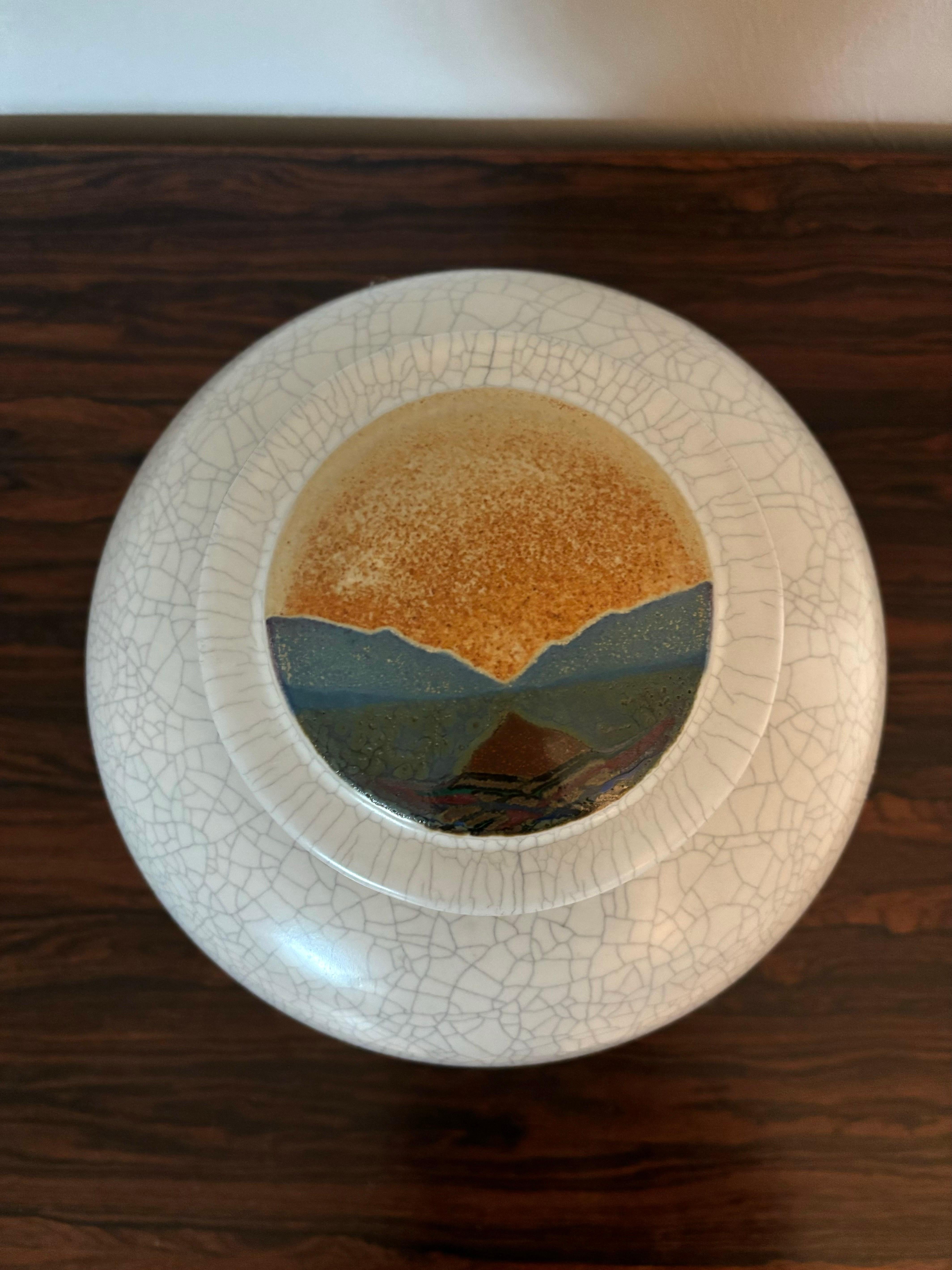 Studio Pottery fatto a mano dell'epoca di metà secolo. Realizzato da Rob Wiedmaier. Adornato con il suo stile caratteristico di un complesso disegno di paesaggio astratto che utilizza un mix di smalti sul coperchio. Il recipiente presenta un
