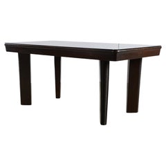 Grande table Robust Dinig avec pieds sculptés et plateau en verre