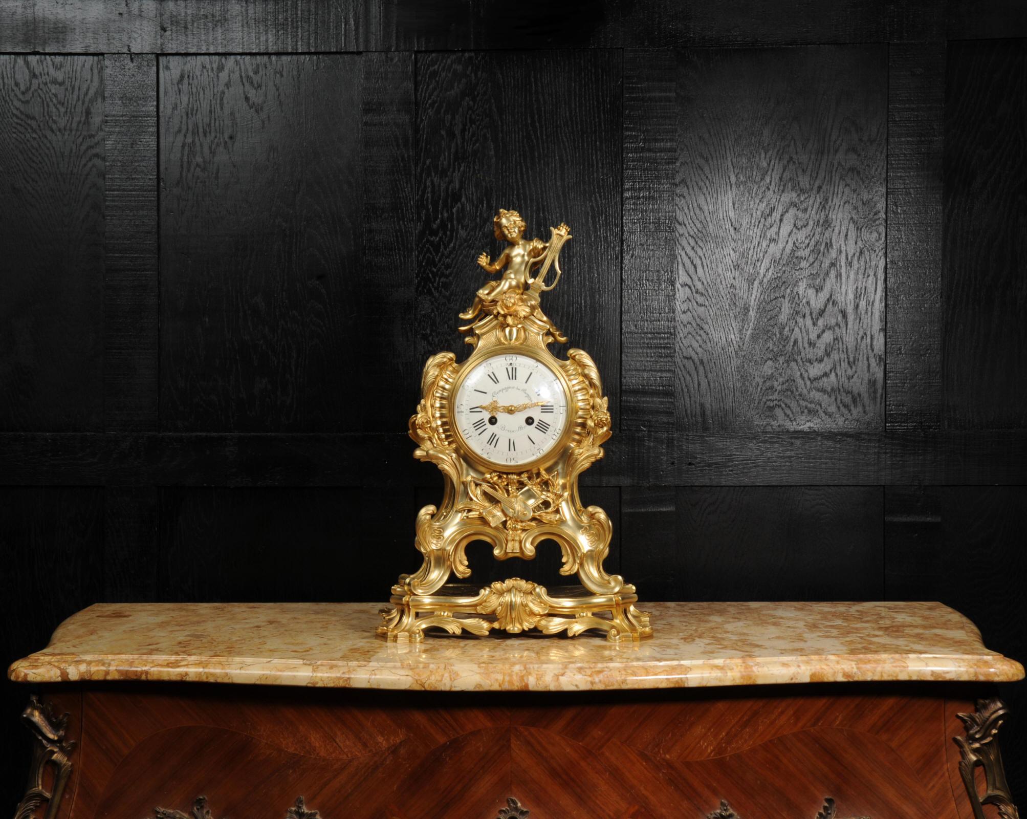 Une superbe et substantielle horloge en bronze doré d'après un dessin du fondeur de bronze du 18ème siècle Robert Osmond et fabriquée par la célèbre Compagnie des Bronze de Bruxelles. De style Louis XV, cette élégante boîte à pans coupés est formée