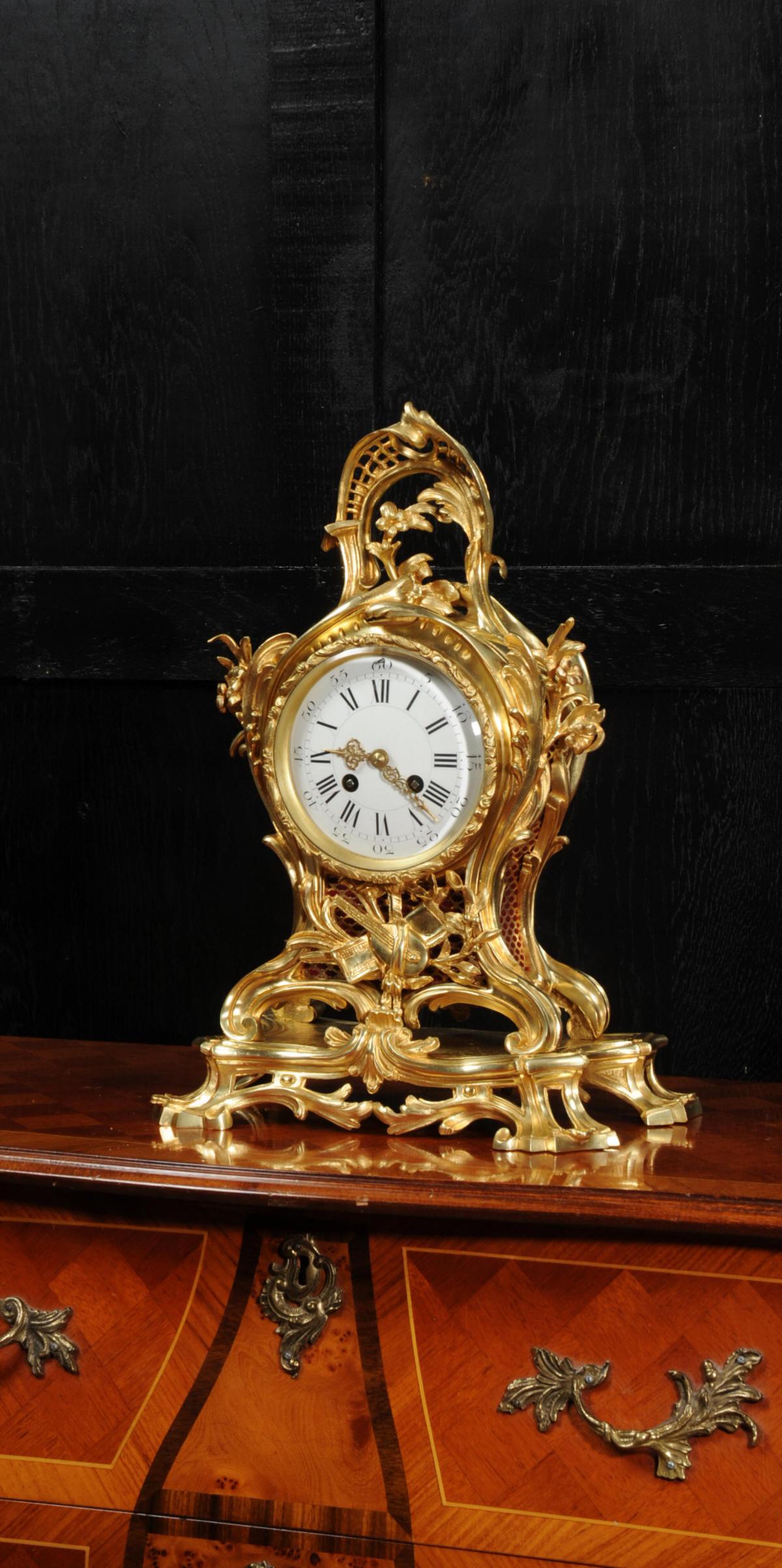 A superb antique French Rococo clock, circa 1880, beautifully modelled and finished in ormolu (finely gilded bronze or doré bronze). Louis XV in style, formed of elegant curves and counter curves, decorated with a trellis and floral swags. Below the