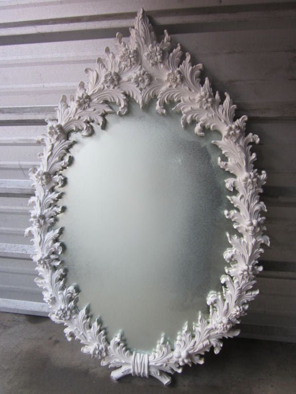 Large Rococo style mirror. Rococo style wall mirror with an oval shape. Beautiful floral pattern with a resin, white painted frame. In the style of Marc Bankowsky or Serge Roche.
